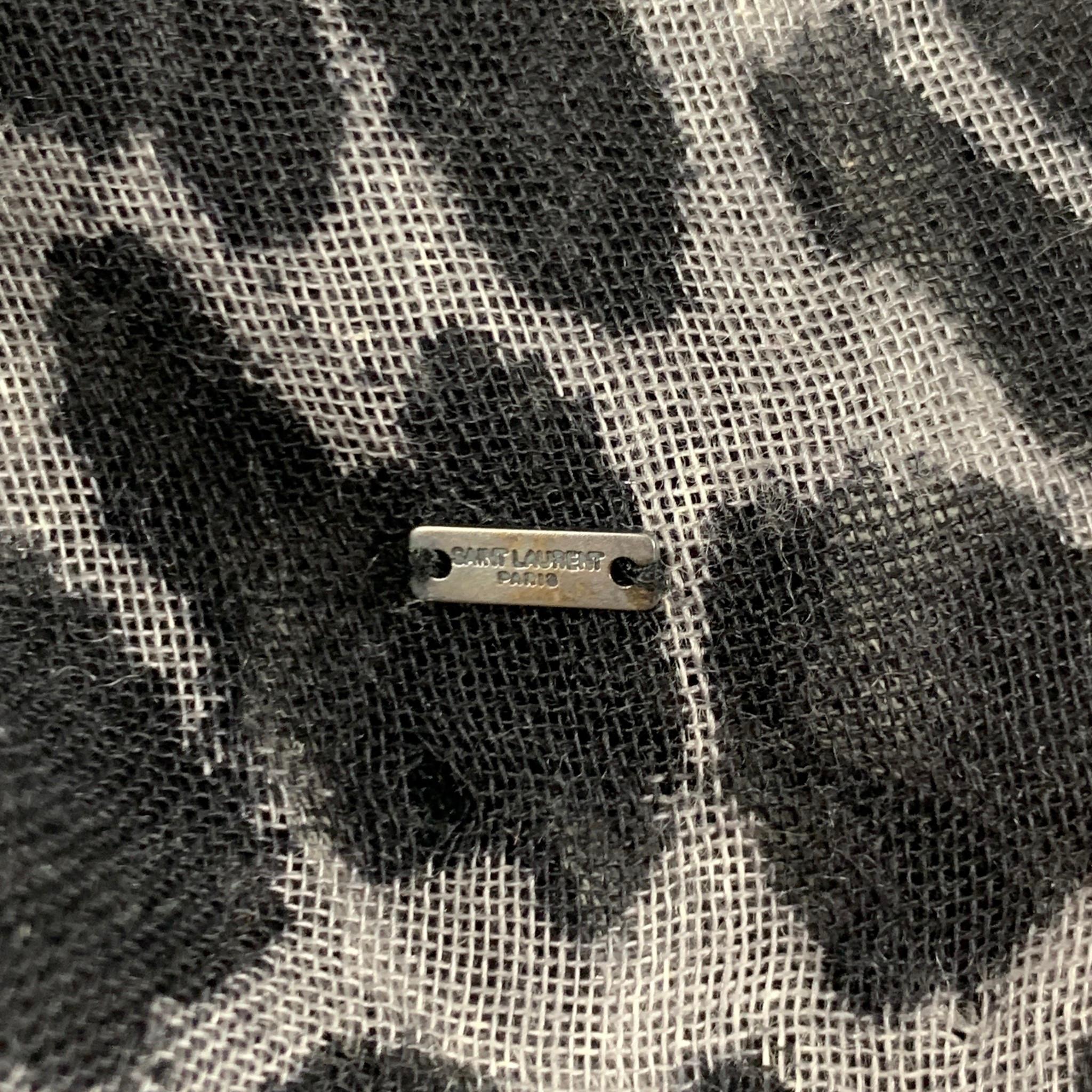 YVES SAINT LAURENT scarf comes in a black & white animal print material with a fringe trim. Made in Italy. 

Very Good Pre-Owned Condition.

Measurements:

54 in. x 52 in.