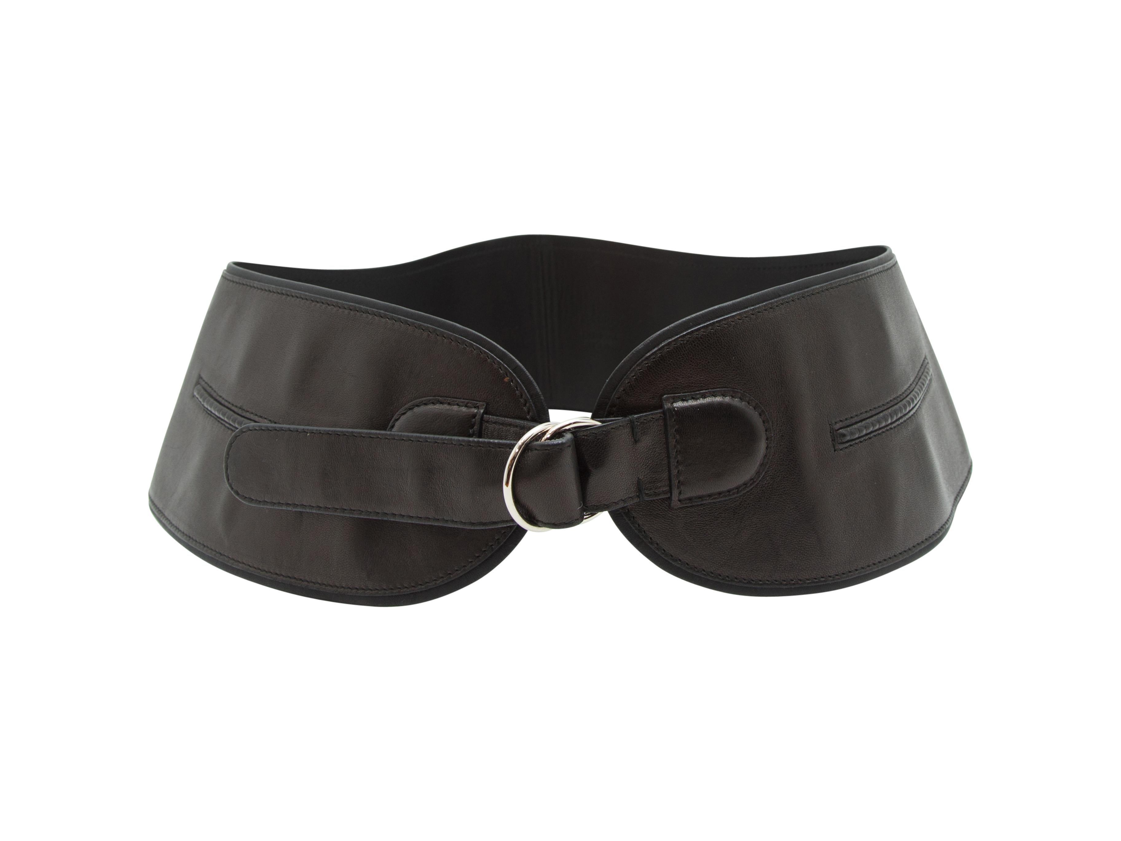 Product details: Black leather wide belt by Yves Saint Laurent. Tonal stitching throughout. Silver-tone D-ring closure at front. 4