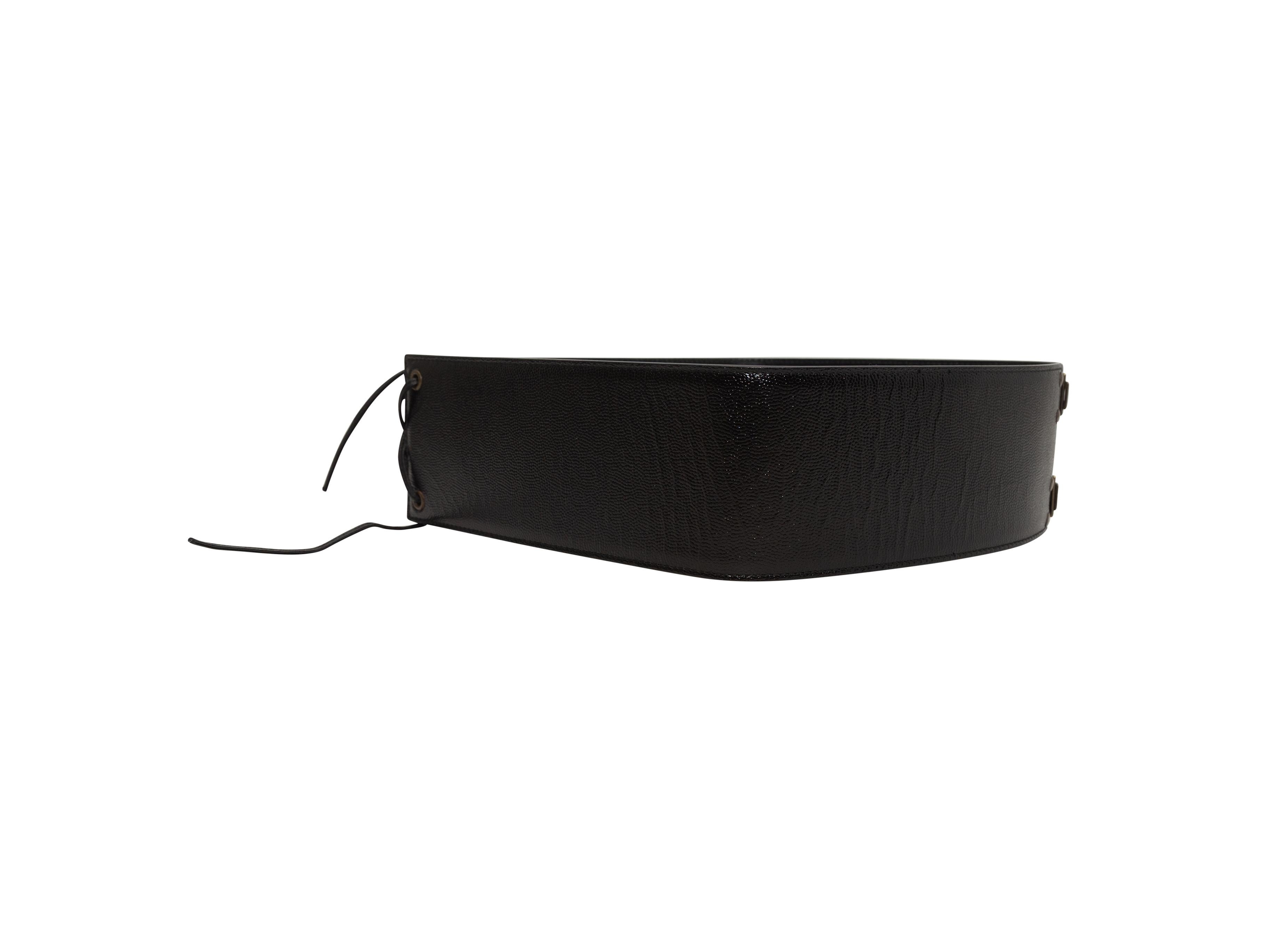 Product details: Vintage black wide leather belt by Yves Saint Laurent. Lace-up detailing at back. Brass hook-and-eye closures at front. 3.25