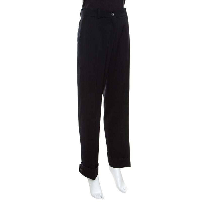 Chic, fashionable and very modern, these straight trousers from Yves Saint Laurent are a must buy! The black trousers are made of 100% wool and feature a simple structured silhouette. They flaunt a crochet lace trim detailing on the rolled bottom