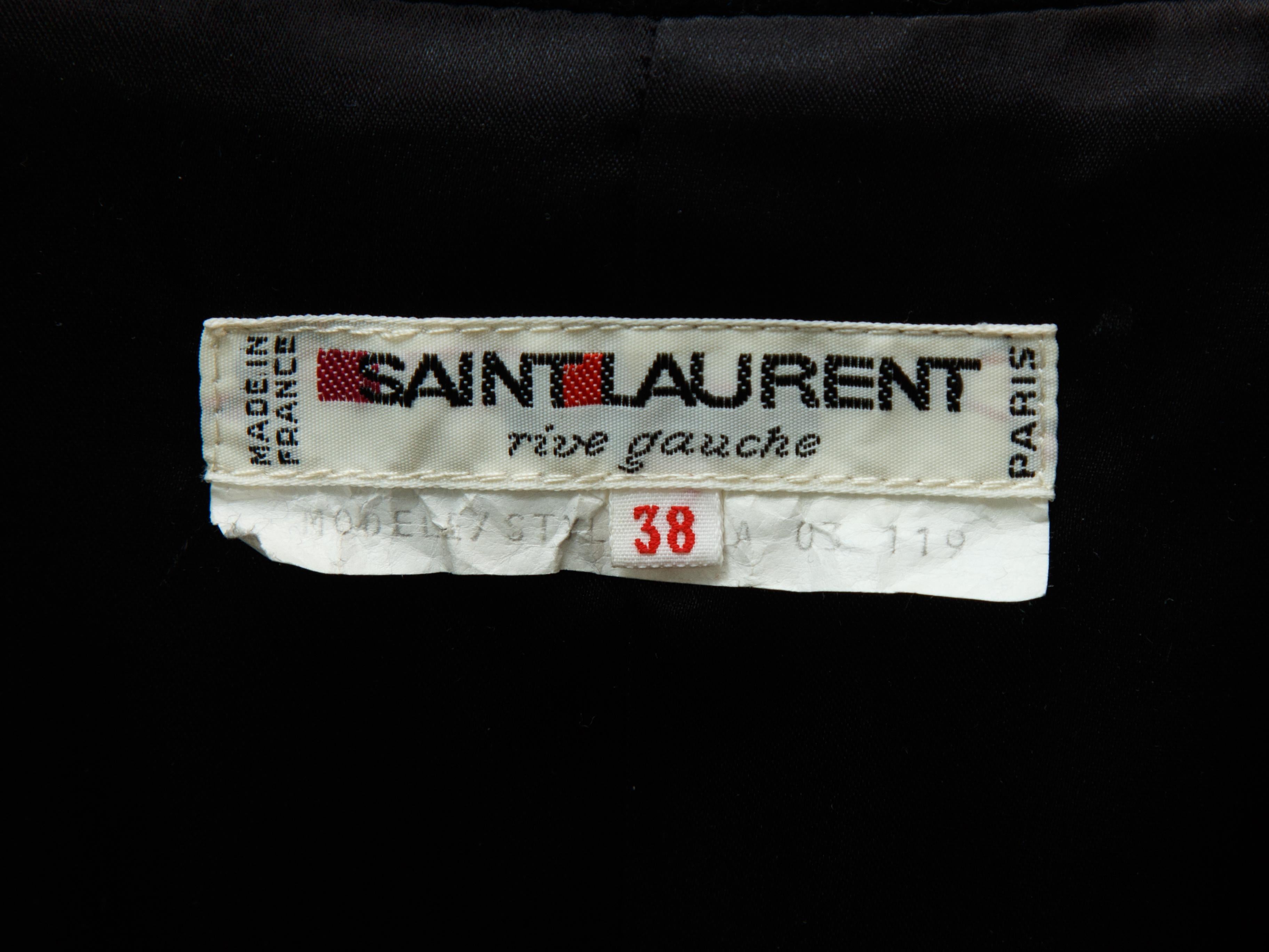 Product details: Vintage black wool jacket by Yves Saint Laurent. Pointed collar. Three pockets. Grosgrain trim throughout. Button closures at front. Designer size 38. 34