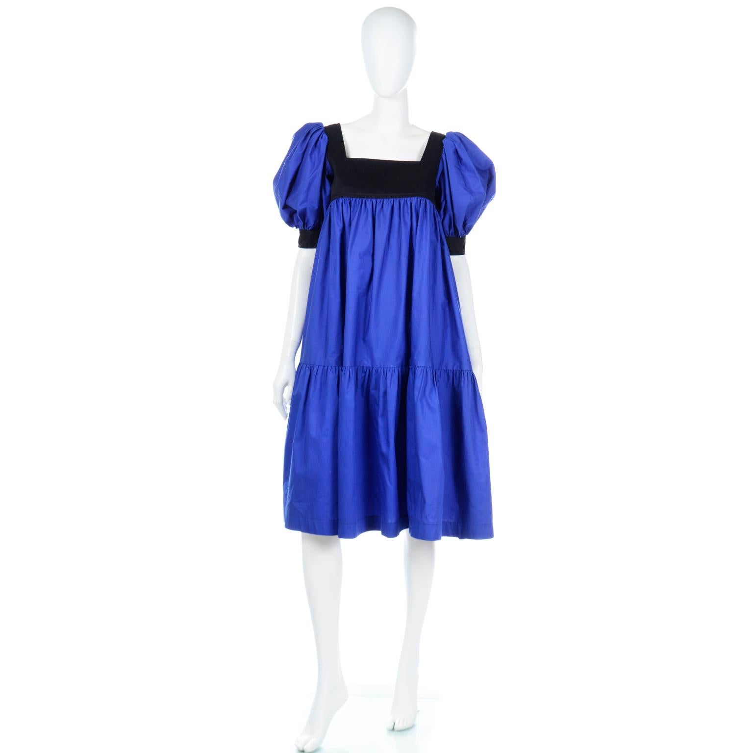 This iconic late 1970s or early 1980s Yves Saint Laurent vintage peasant style dress is in a rich royal blue cotton poplin with black accents at the yoke and cuff of the sleeves. YSL was often inspired by other cultures and communities, and he