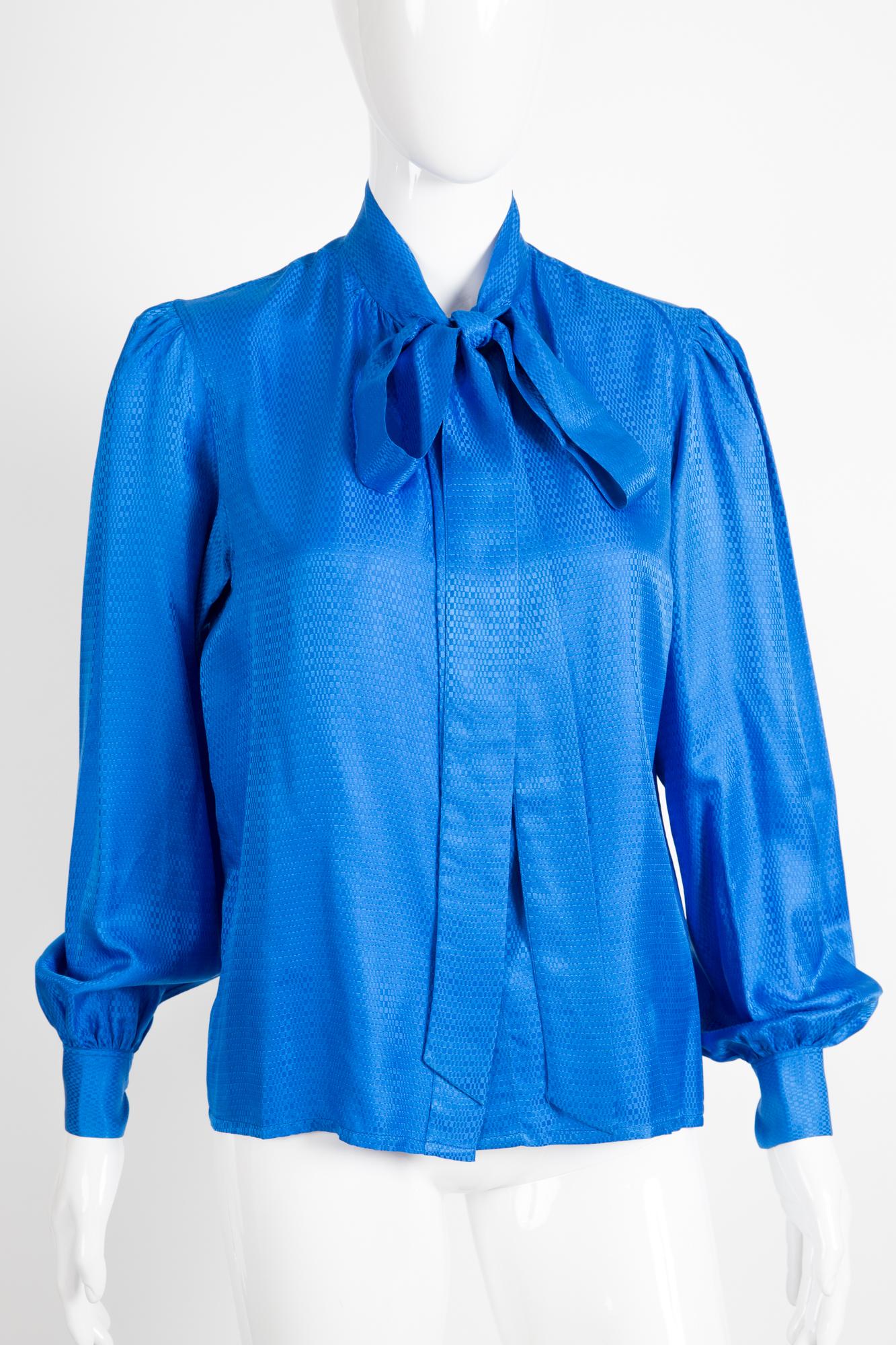  Yves Saint Laurent blue silk shirt featuring a bow tie, front buttons, a textured jacquard silk. front button opening under placket, long sleeves. 
100% Silk
In excellent vintage condition. Made in France. 
Estimated size 38fr/US6 /UK10
We