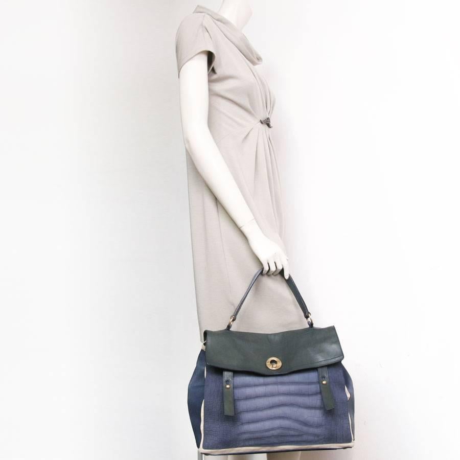 Yves Saint Laurent Muse II bag in two-tone green and blue leather. Gilded metal hardware. The lining is in ecru canvas. 
There are 3 compartments. There is also an outside pocket that closes with 3 buttons (a centimeter unsheathed).
In good