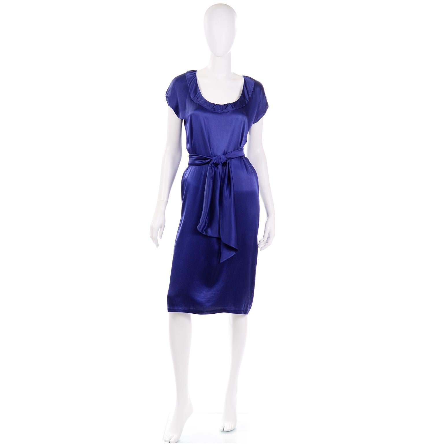 This is a stunning Yves Saint Laurent rich saturated blue silk charmeuse dress with its original matching belt.  The neckline is a wide scoop neck with a gathered center and the sleeves are a dolman cap sleeve with an elastic arm opening. This dress