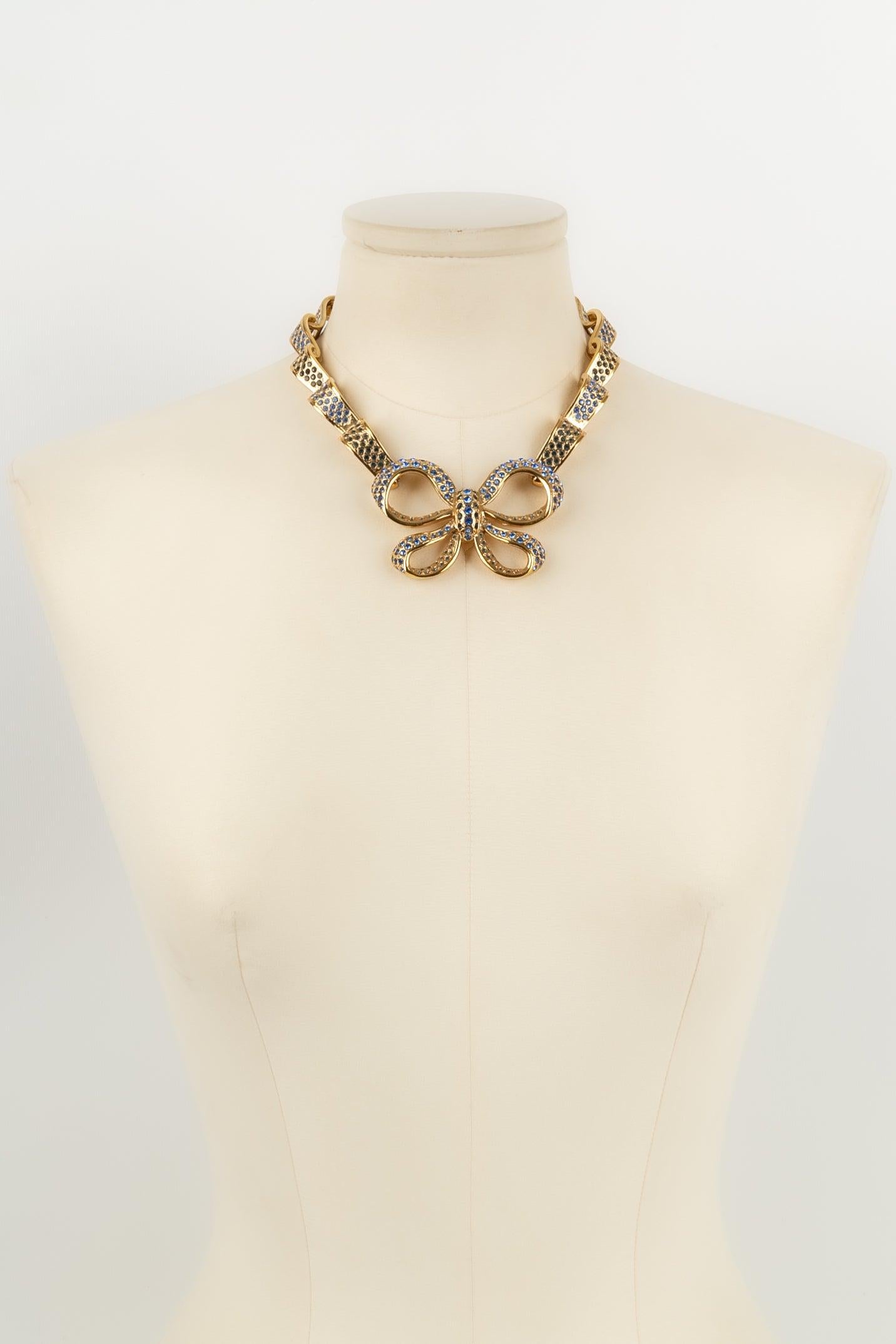 Yves Saint Laurent - (Made in France) Bow necklace in gold metal and blue strass.

Additional information: 
Dimensions: Length: 39 cm
Condition: Very good condition
Seller Ref number: BC10