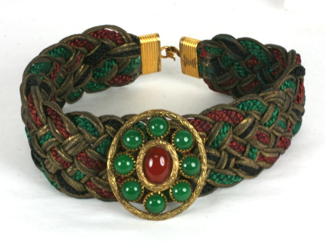 Yves Saint Laurent Braided Jeweled Haute Couture Choker of colored braid and gold lame ribbon with jeweled central motif of pate de verre carnelian and green onyx cabochons set in a gilt filigree frame. Deep ruby, emerald and jet silk braid are