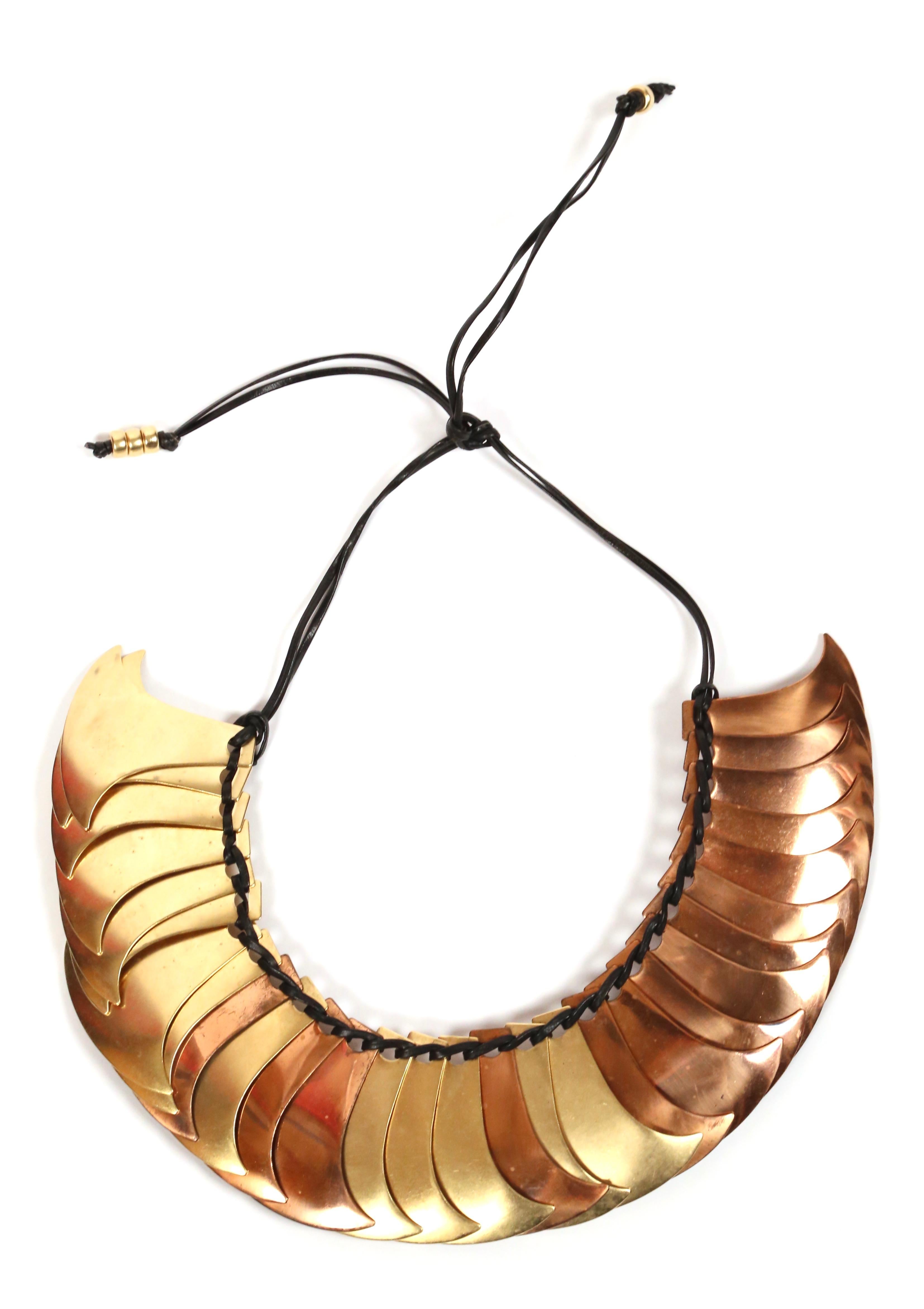 Sculptural brass and gilt metal pieces make up this dramatic collar from Yves Saint Laurent as seen on the spring 1983 runway. This is a very rare and unique piece.  Beautiful patina to metal. Strung on cord with beads at ends. Approximate