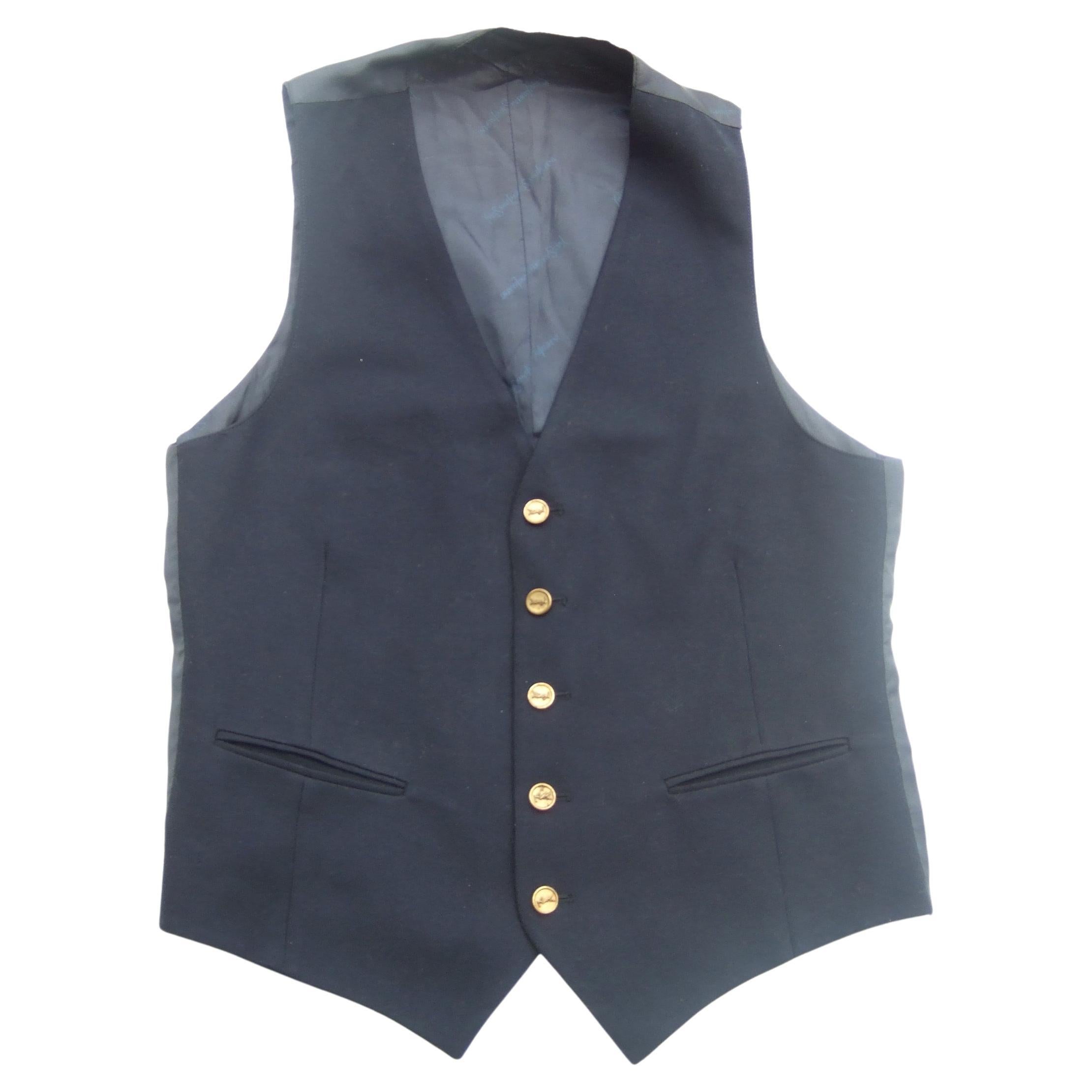 Yves Saint Laurent Dark blue wool men's - unisex vest adorned with YSL brass metal buttons c 1970s

The classic dark blue wool vest is designed with a pair of slit pockets on the lower front section. The backside & interior are constructed with