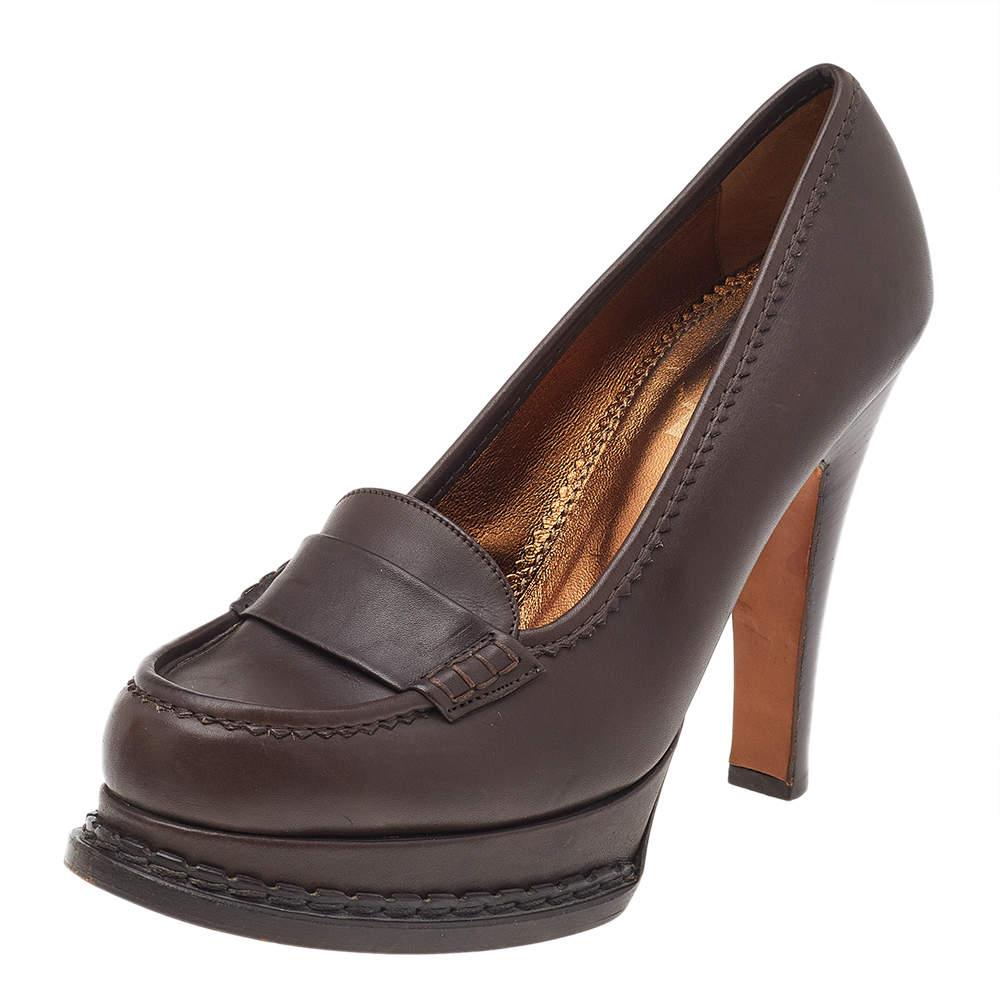 Enrich your formal style as you wear these loafer pumps from Yves Saint Laurent. These Tribtoo pumps are created using brown leather on the exterior with a Penny strap detail, platforms, and heels accentuating their structure. Match these pumps with