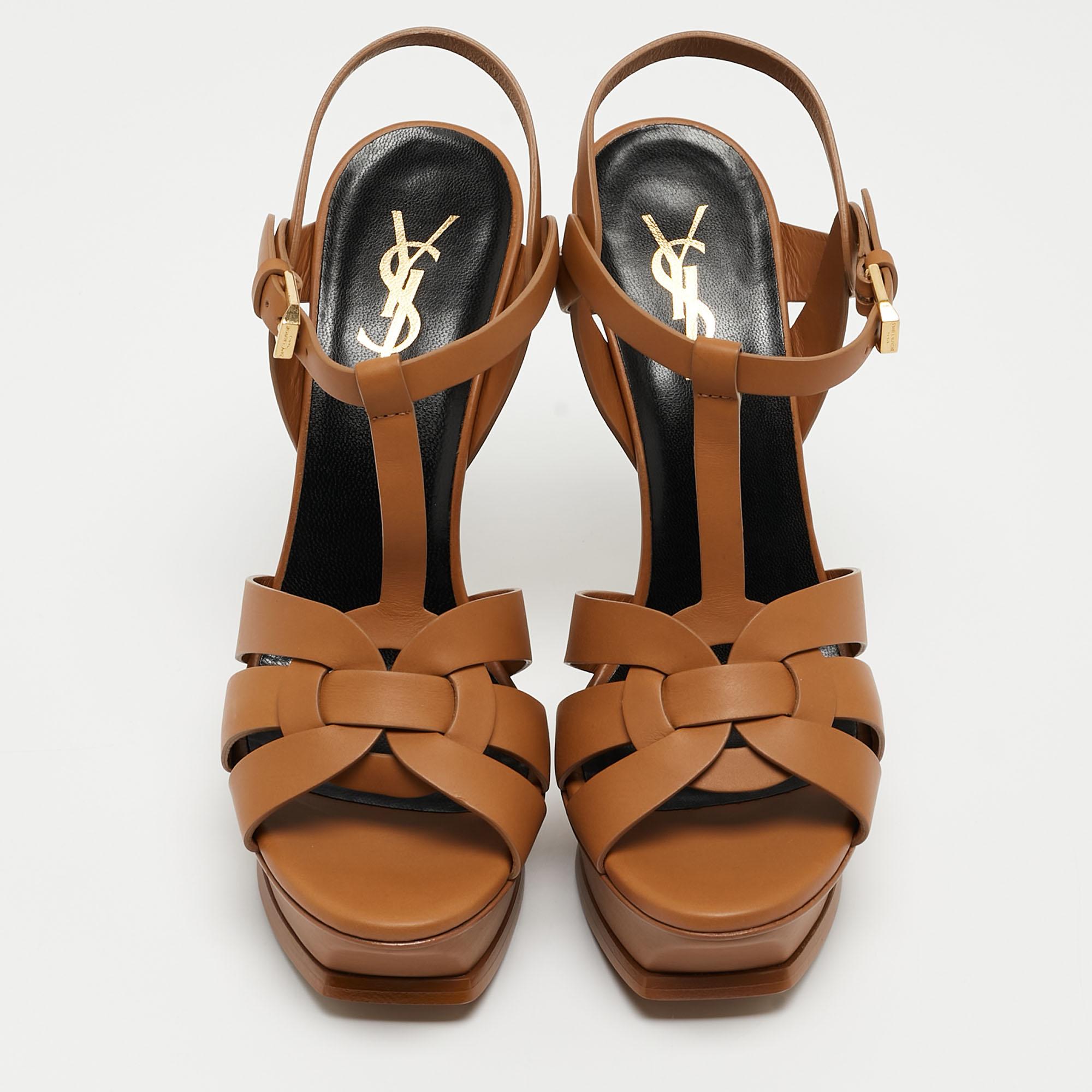 The fashionista in you will fall in love with these Saint Laurent Tribute sandals. They are made from brown leather with intertwined straps on the vamps and ankle buckle closure. The gold-tone hardware, 13cm heels, and platform give this pair a fine