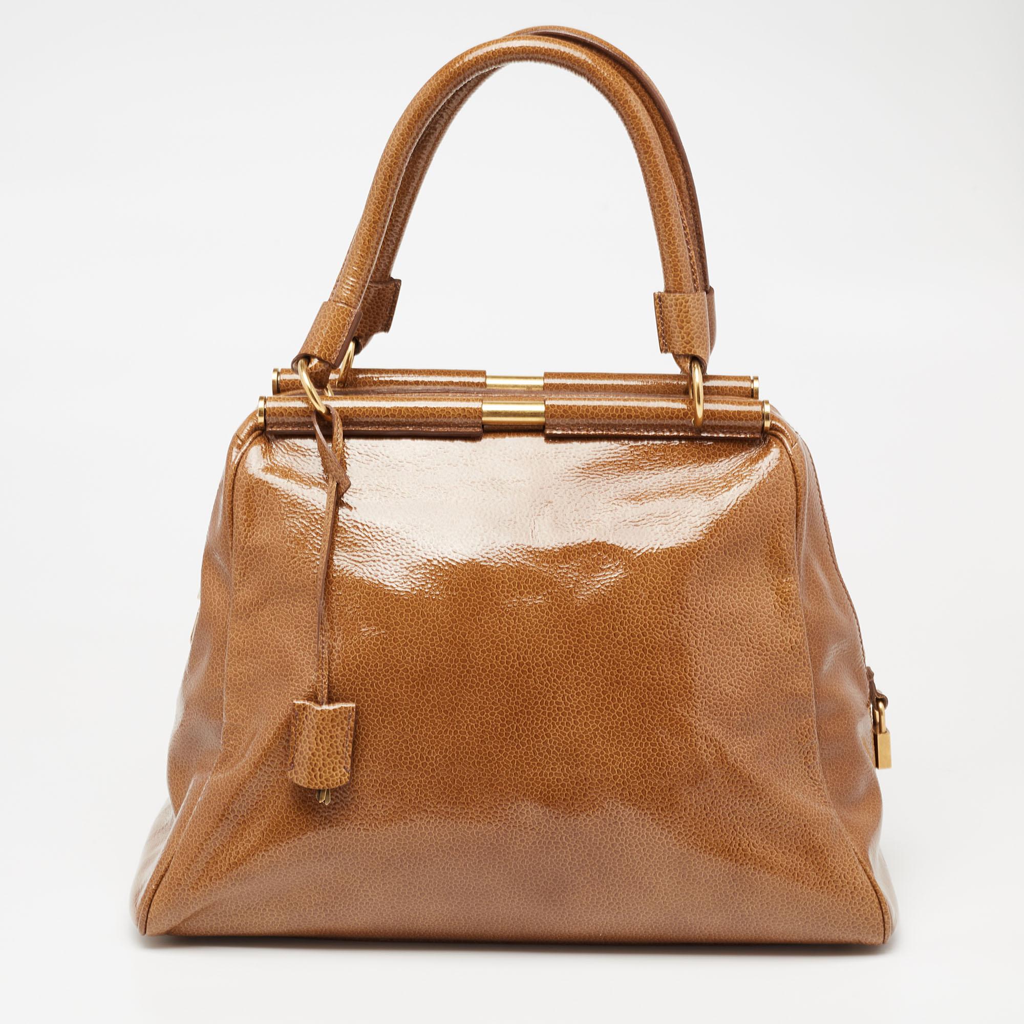 Questa borsa Majorelle di Yves Saint Laurent è stata progettata per offrire funzionalità e stile allo stesso tempo. È realizzata in pelle verniciata marrone e decorata con hardware color oro per un look elegante. La forma spaziosa è sostenuta da due