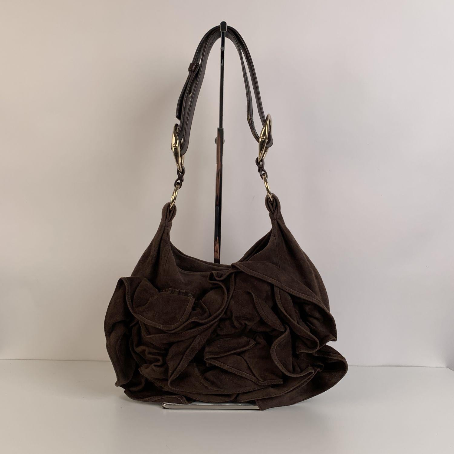 Yves Saint Laurent 'Nadja Rose' Shoulder Bag, crafted in brown suede. It features a ruffled rose detail on the front. Magnetic button closure on top. Brown suede lining. 1 side zip pocket and 1 side open pocket inside. 'yves Saint Laurent Rive