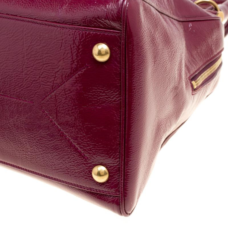 Puoi sicuramente contare su questa adorabile borsa Majorelle di Saint Laurent Paris per un look di tendenza. Realizzata in pelle verniciata, presenta un design elegante e strutturato con due aste in metallo sulla parte superiore. Presenta una