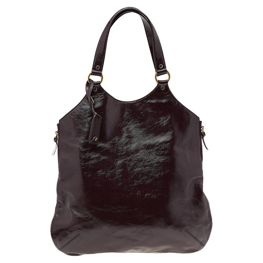 Not only is this large Tribute tote from Yves Saint Laurent ultra-modern, but also chic, classy, and artistic. This burgundy wonder is crafted from patent leather. The bag features dual shoulder straps and gold-tone hardware. With its fabric-lined