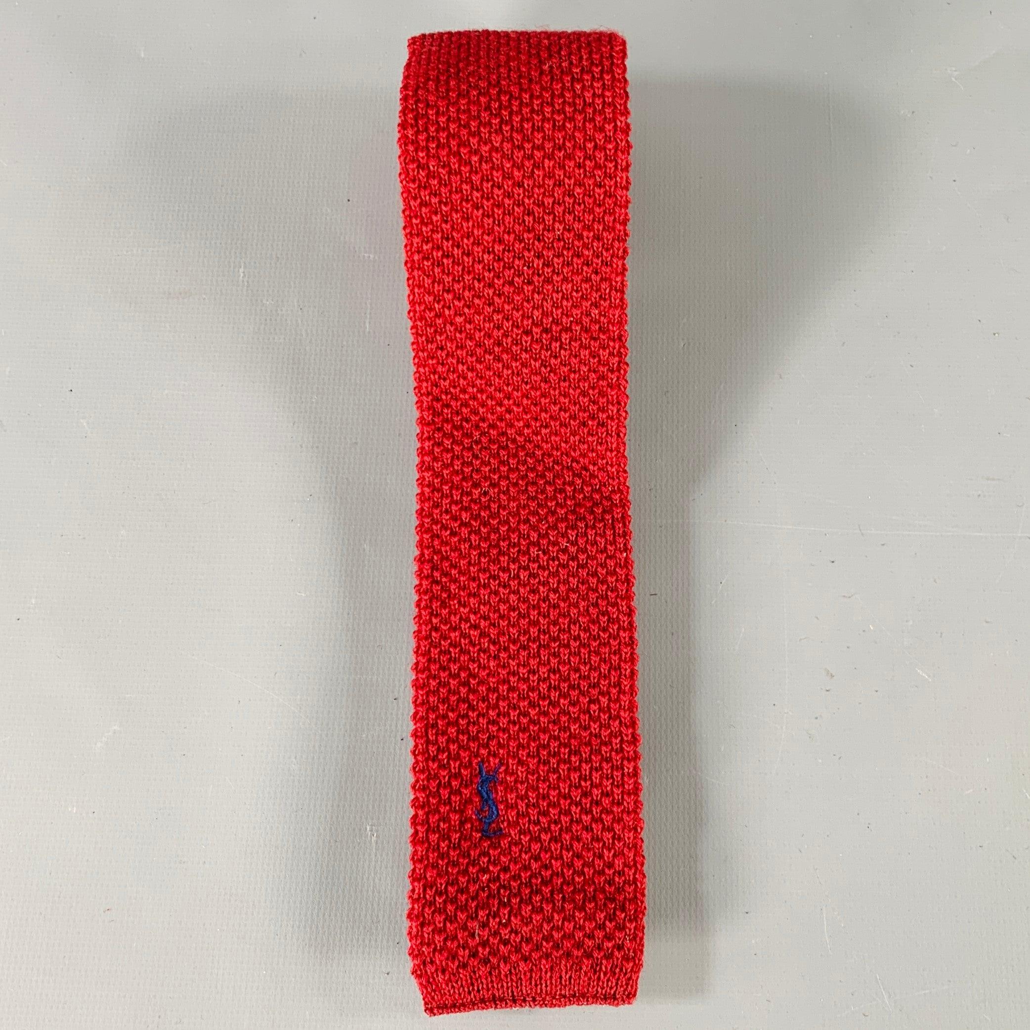 YVES SAINT LAURENT
in a burgundy red wool knit featuring a skinny style, and embroidered YSL monogram detail.Good Pre-Owned Condition. Moderate signs of wear on back, as is. 

Measurements: 
  Width: 2 inches Length: 46 inches 
  
  
 
Sui Generis