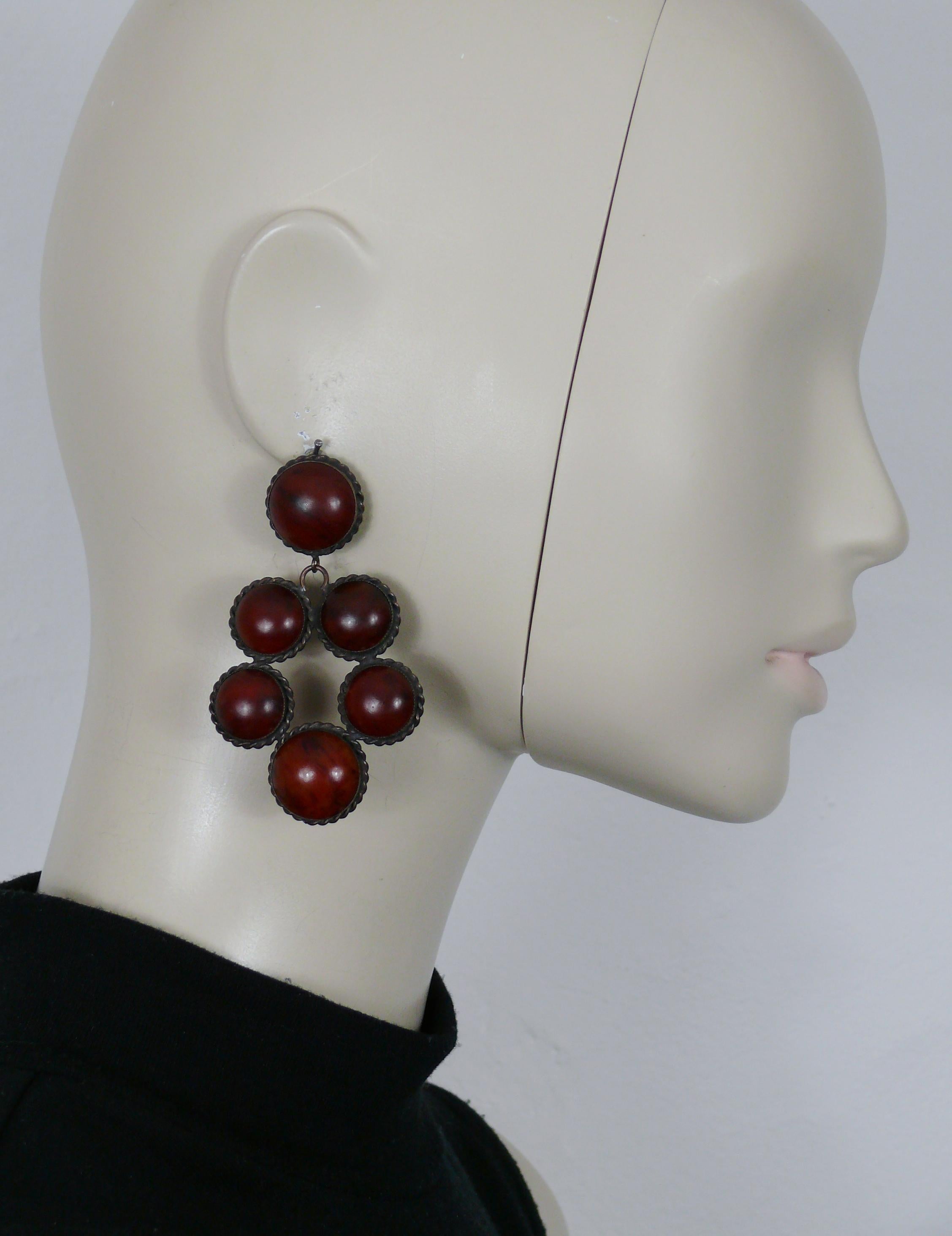 Boucles d'oreilles pendantes (clip-on) YVES SAINT LAURENT par ROGER SCEMAMA, patine canon de fusil vintage, avec cabochons de résine en fausses pierres marbrées de couleur ambre.

Embossé YSL.

Mesures indicatives : hauteur env. 7,4 cm (2.91 inches)