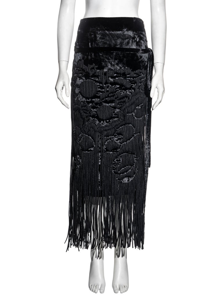 ▪ Yves Saint Laurent silk velvet evening skirt 
▪ Designed by Tom Ford
▪ Black silk velvet 
▪ Abstract pattern made up with a multitude of woven laces 
▪ Long fringe trim
▪ Attached belt 
▪ Silk chiffon lining 
▪ FR 34 - UK 6 - US 2
▪ Fall-Winter