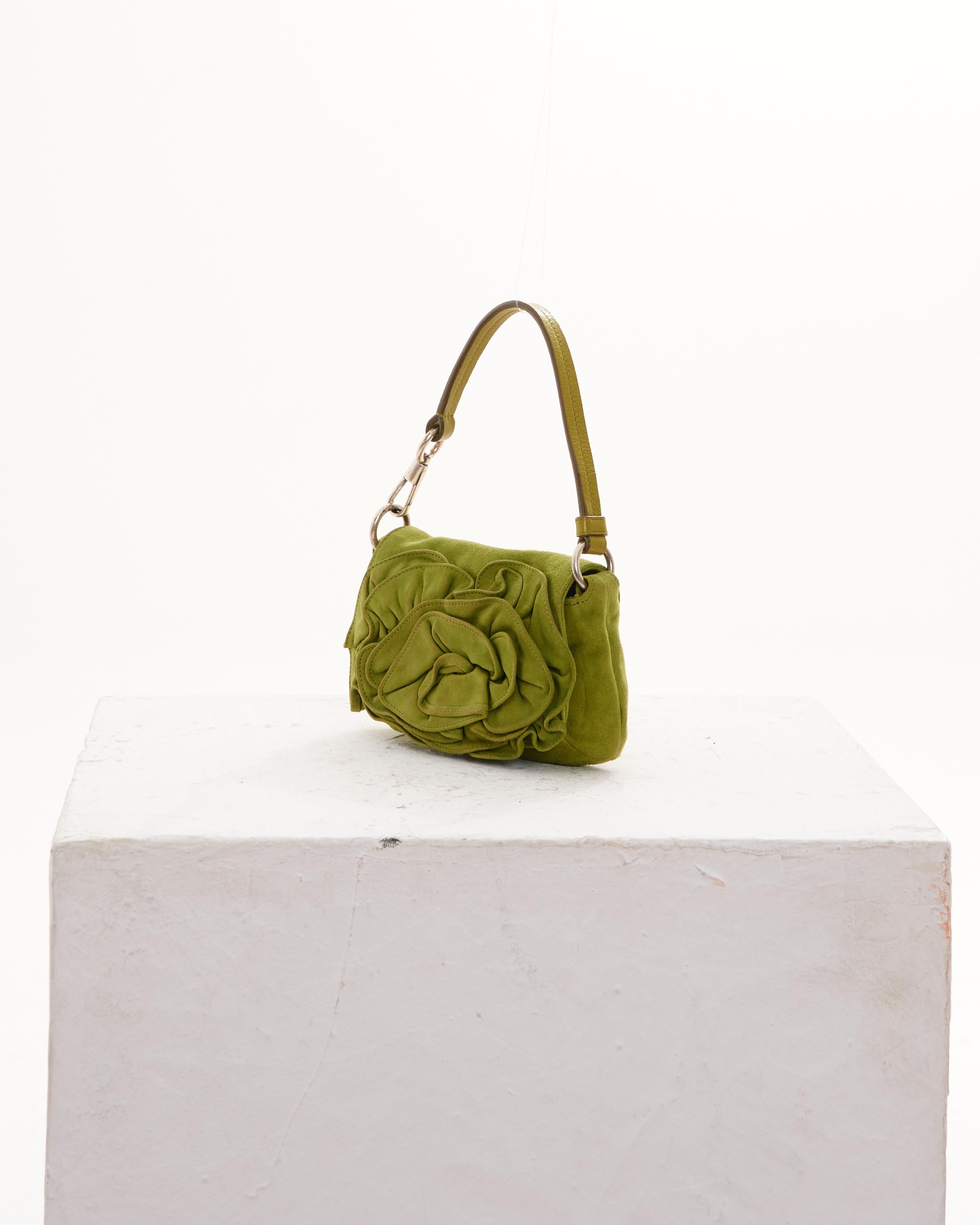- Yves Saint Laurent by Tom Ford green suede Nadja handbag 
- Supple green suede on the exterior with a rosette detail
- Silver hardware 
- Strap can be removed at one side
- One main interior compartment in green leather with side pocket 
-