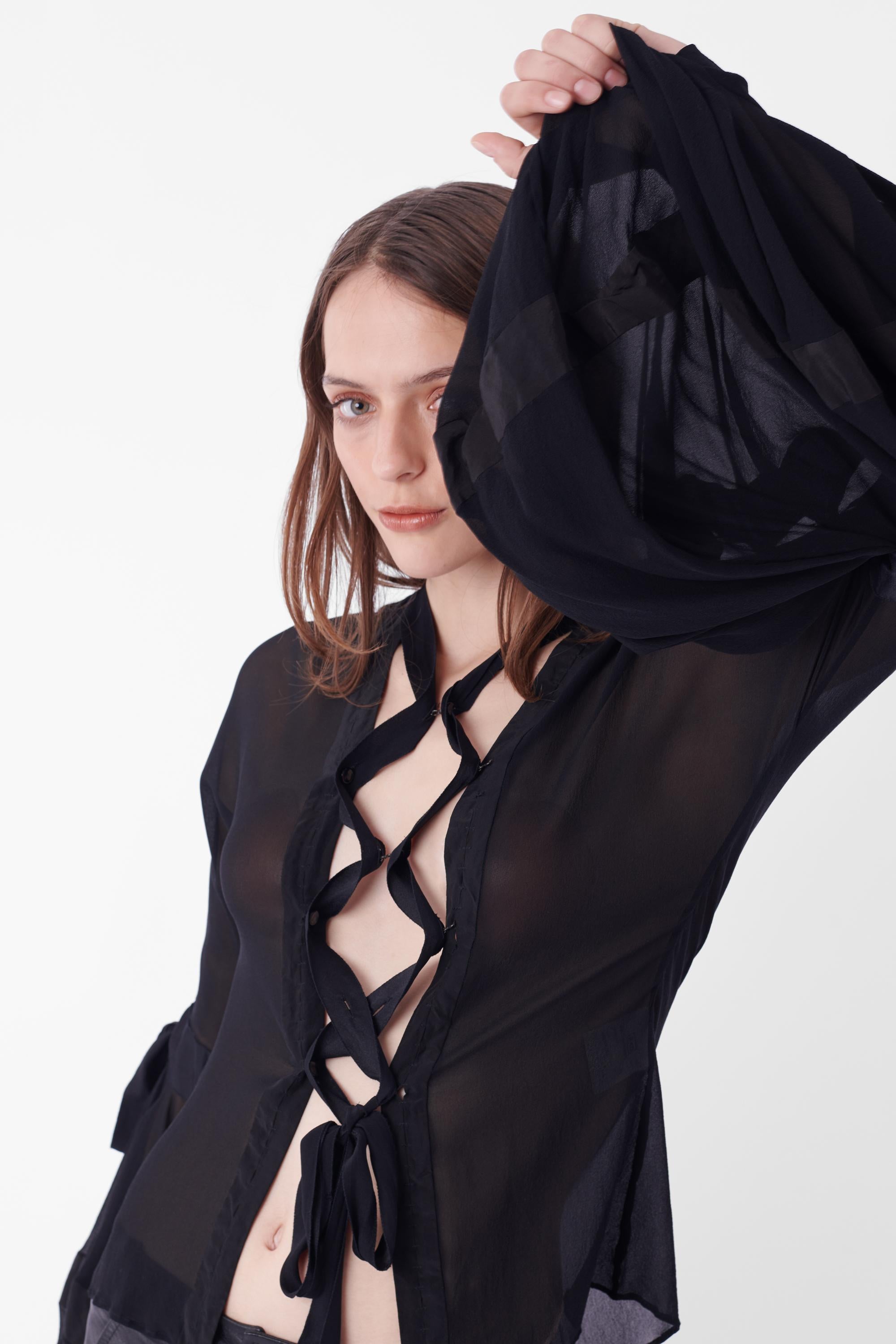 Yves Saint Laurent by Tom Ford Fall Winter 2002 lace up front black blouse. Runway look 3, as featured in a number of campaigns. Features iconic cross over detailing, semi-sheer body, balloon billow sleeves and button cuff closure. In great vintage