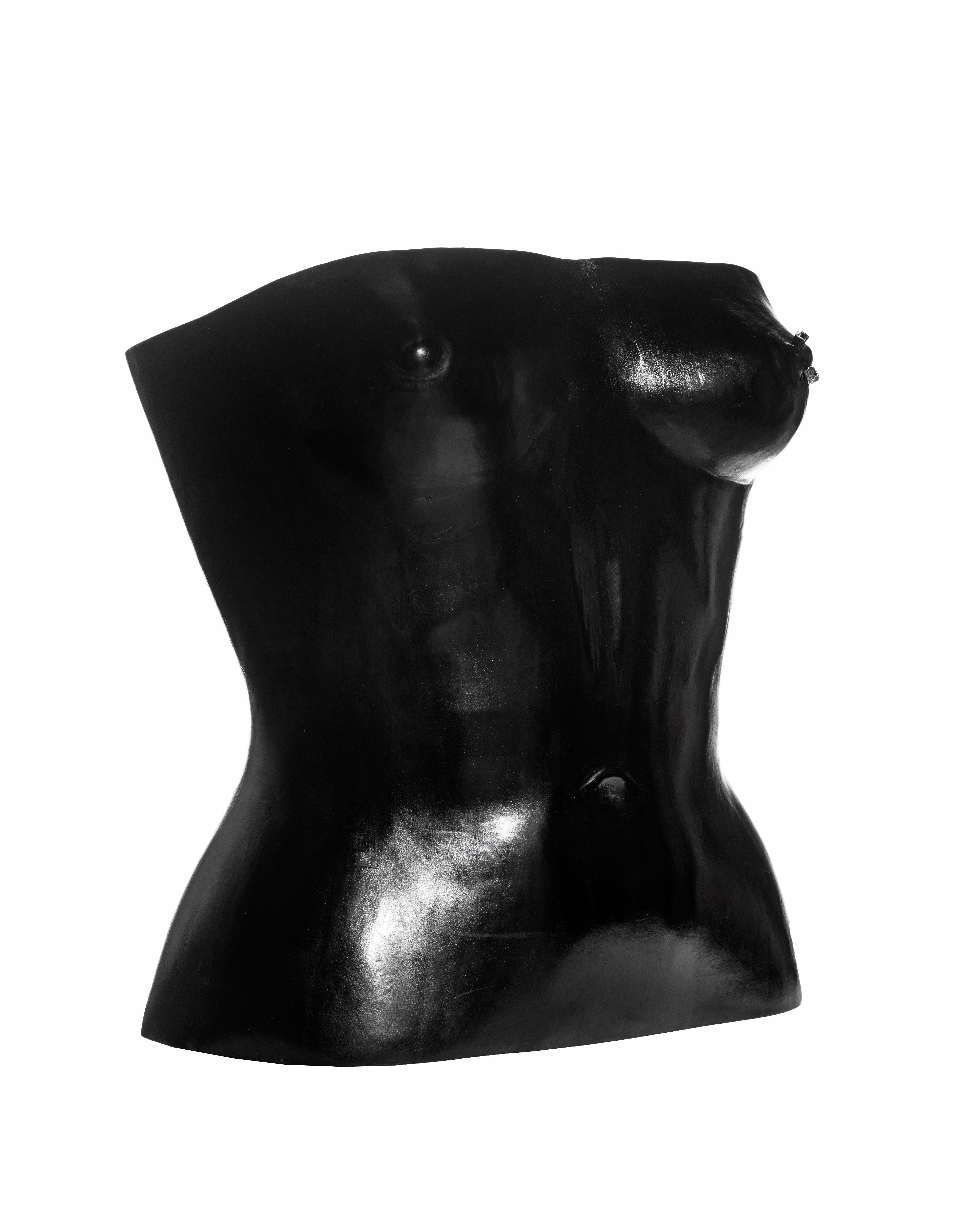 ▪ Rare Yves Saint Laurent showpiece ensemble 
▪ Designed by Tom Ford for his first collection at Yves Saint Laurent
▪ Museum piece
▪ Black leather corset moulded to a naked torso of a woman 
▪ Silver nipple piercing with two square cut crystals 
▪