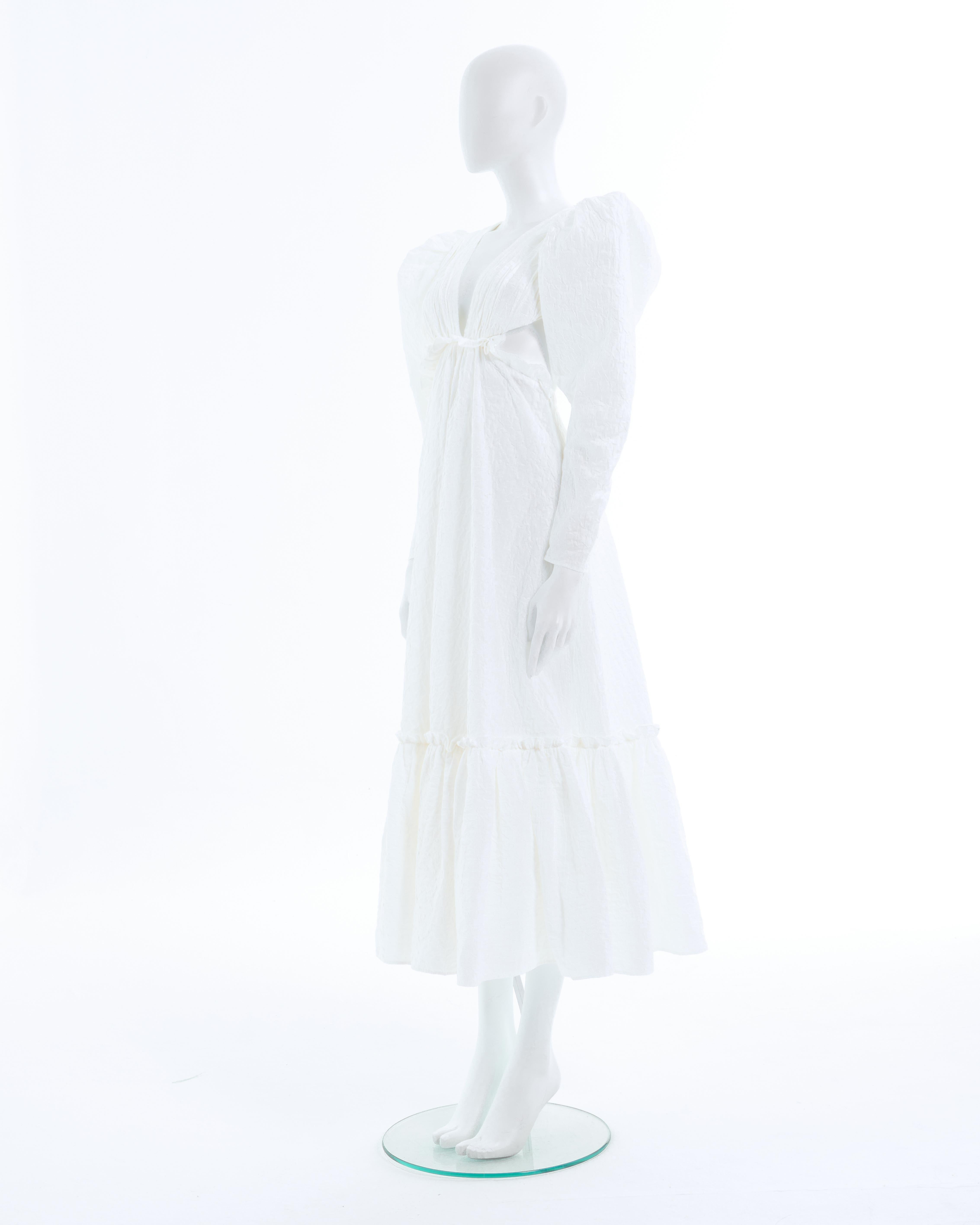 - Yves Saint Laurent designed by Tom Ford white lace-up cotton blend maxi dress
- Sold by Skof.Archive 
- Spring-Summer 2001 
- White cotton puff sleeve maxi dress
- Deep V-neck in front and back 
- Lace-up fastening back closure 
- Deliberately