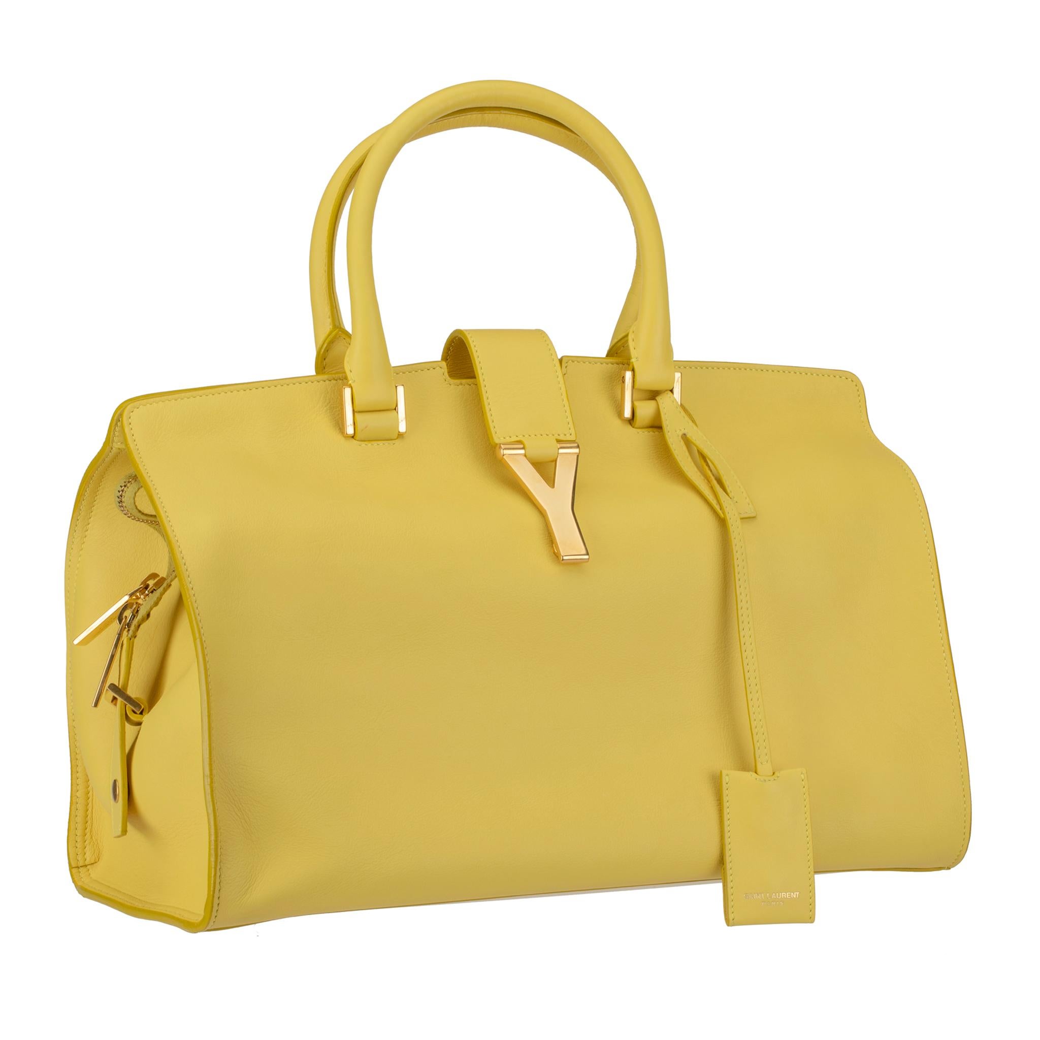 This Saint Laurent Paris yellow Cabas Chyc tote bag is perfect for everyday usage. The bag is made of leather and features a gold-tone Y motif snap clasp, twin wrapped handles, and metal feet at the bottom.
A roomy suede lined inside with a zip
