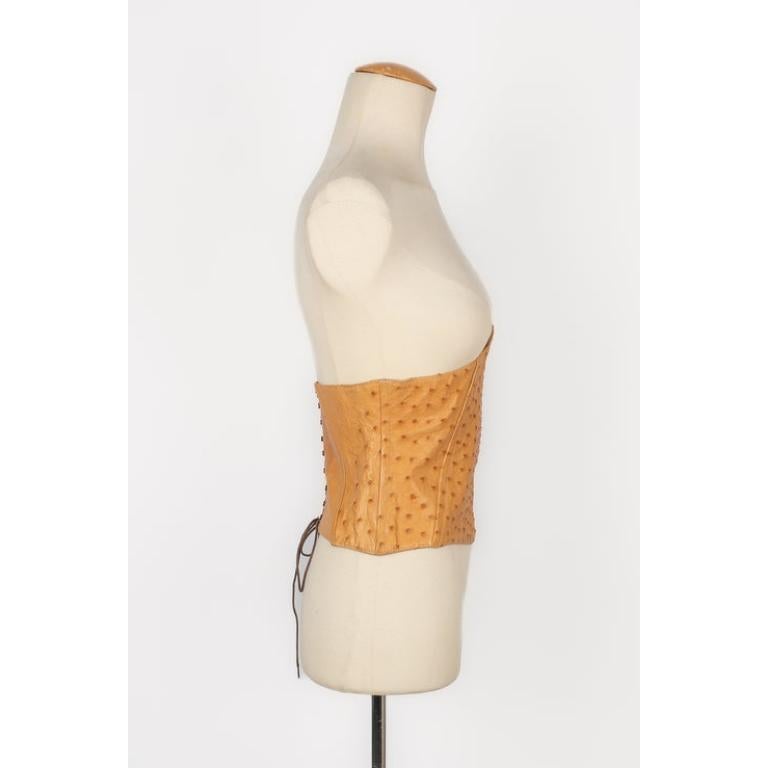 Yves Saint Laurent - (Made in France) Camel-color shiny ostrich leather corset. Metal elements. No size indicated, it fits a size S. 1990 Circa Collection.

Additional information:
Condition: Good condition
Dimensions: Length: 66 cm - Height: 26