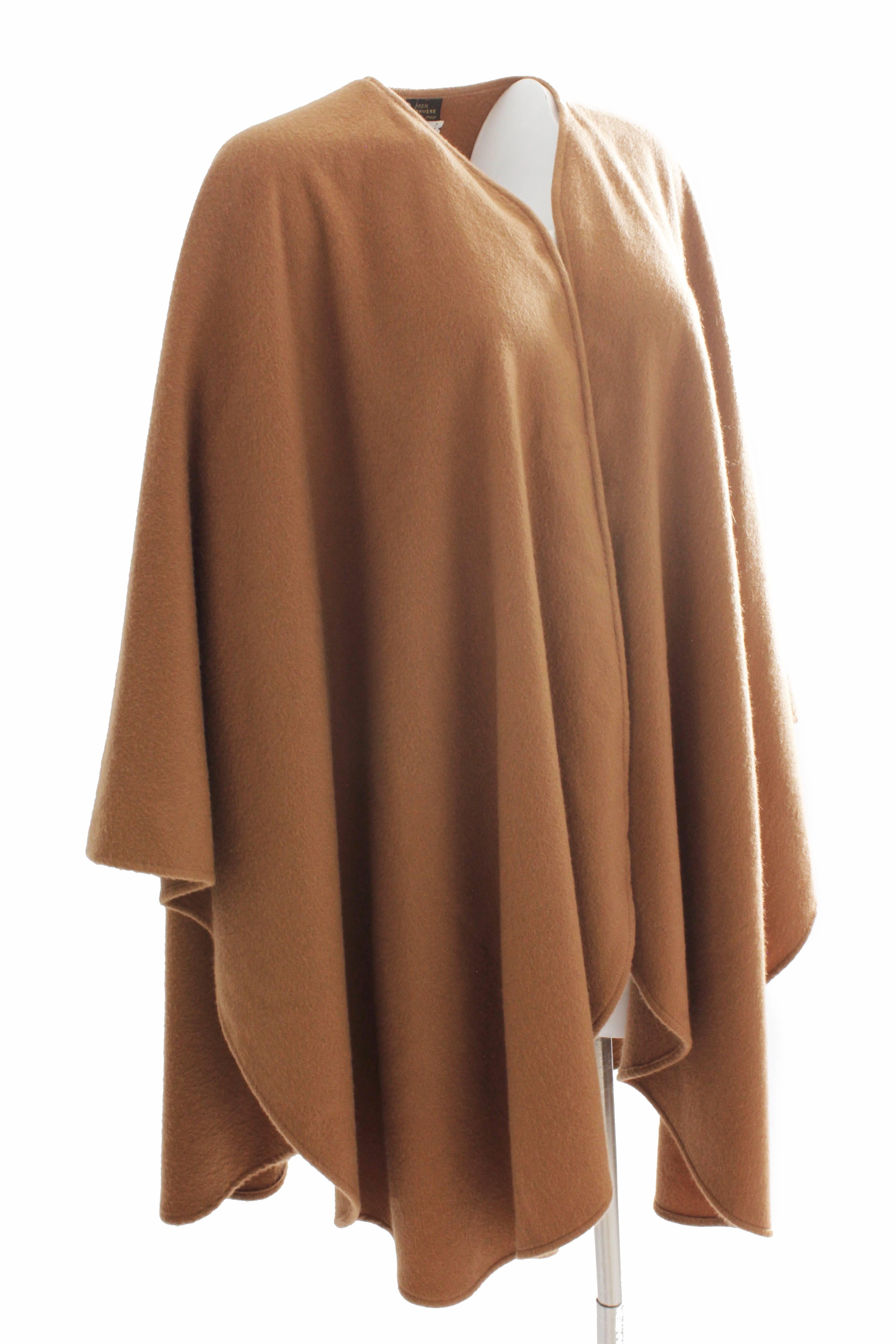 This chic cape or poncho was made by Yves Saint Laurent for the winter 1996/1997 collection.  Made from camel tan cashmere, this piece is elegantly simple and can be styled in so many ways.  Preowned with minimal signs of prior wear.  Unlined.  One