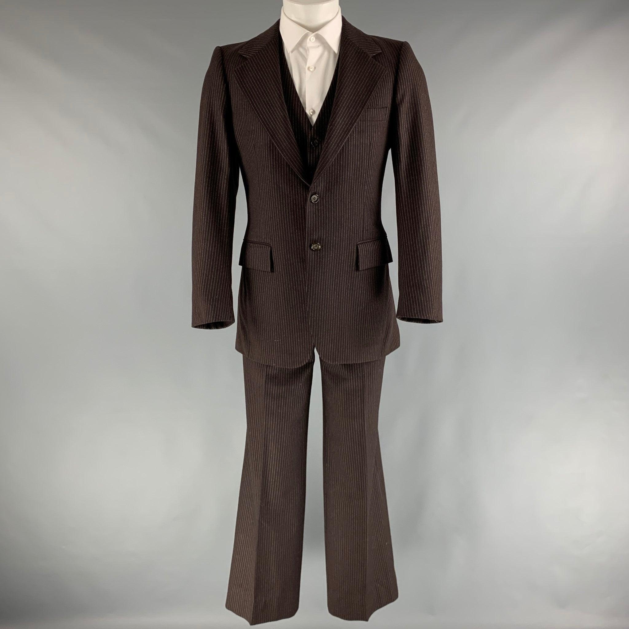YVES SAINT LAURENT 3 Piece suit comes in brown and white pinstriped woven material with a full liner and includes a single breasted, double button sport coat with a notch lapel and a matching vest and flat front trousers. Made in France.Very Good