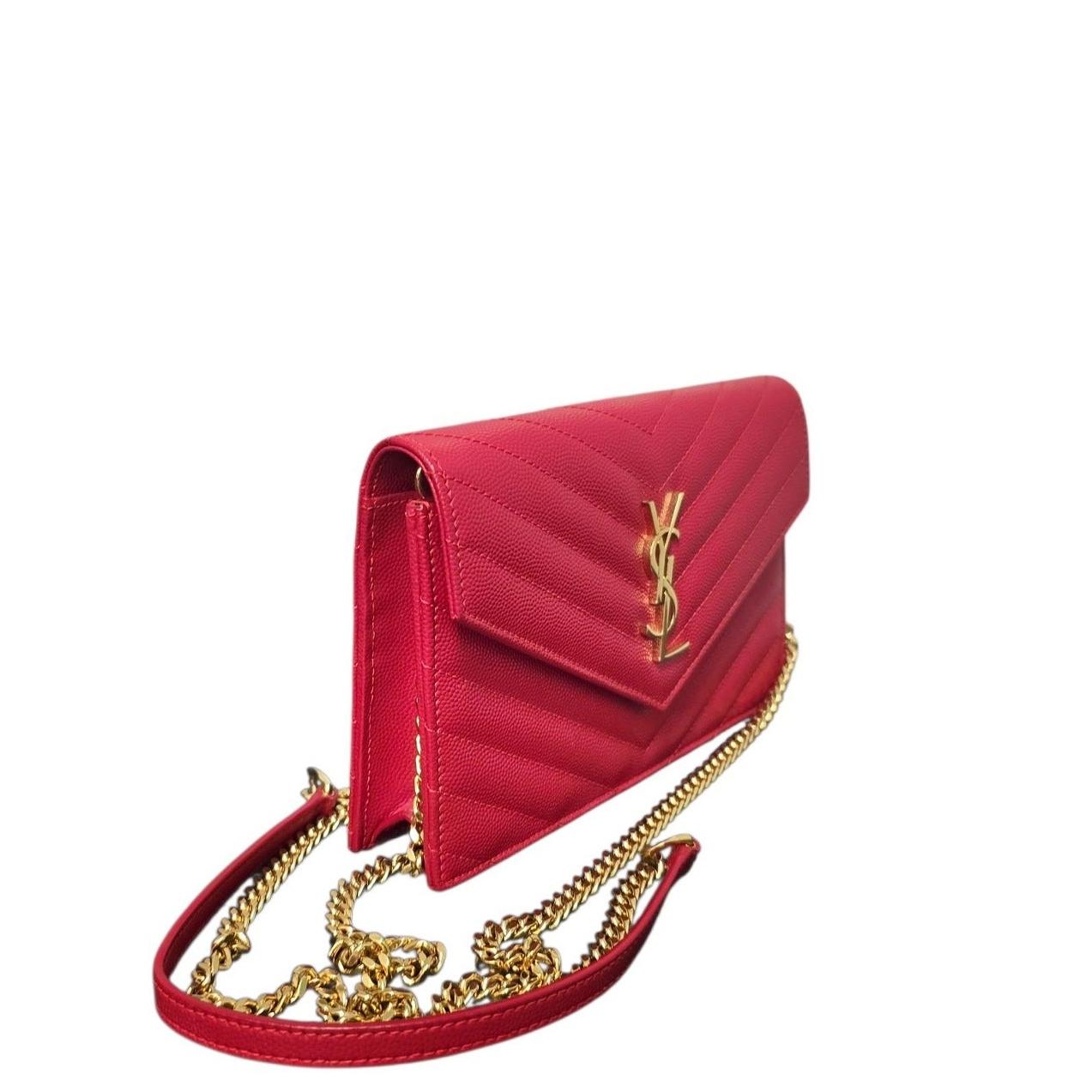 Questo portafoglio con catena Cassandre di Saint Laurent è un esempio di artigianato di lusso grazie alla sua pelle di vitello trapuntata in Rouge Eros. L'iconico logo YSL è presente nella chiusura a busta, mentre la tracolla a catena rimovibile in