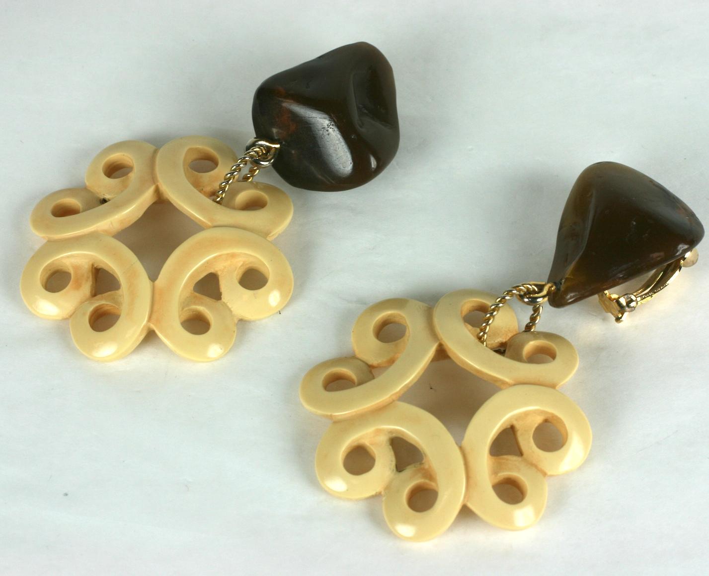 Yves Saint Laurent Chinese Collection long pendant ear clips with asymetrical brown resin pebble ear tops suspending round infinity motifs of carved and patinaed  faux ivory. 
Excellent Condition. Signed YSL. Clip back fittings. 
Length  3.50