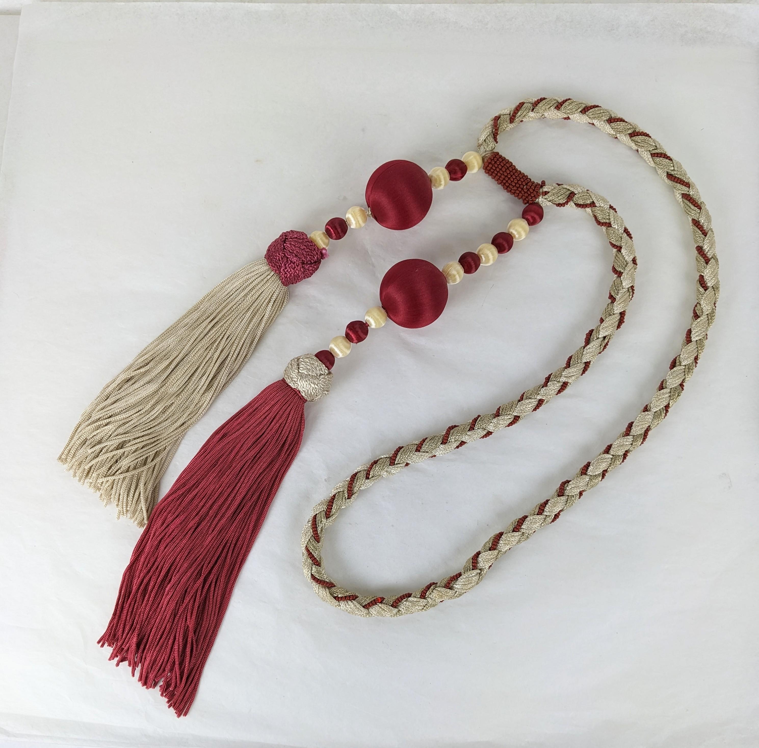 Yves Saint Laurent Chinese Collection passementerie sautoir. Composed of palest ivory braided cord woven with tiny burgundy seed beads. Two large ivory colored and burgundy colored tassels are enhanced with large and small silk beads to form the