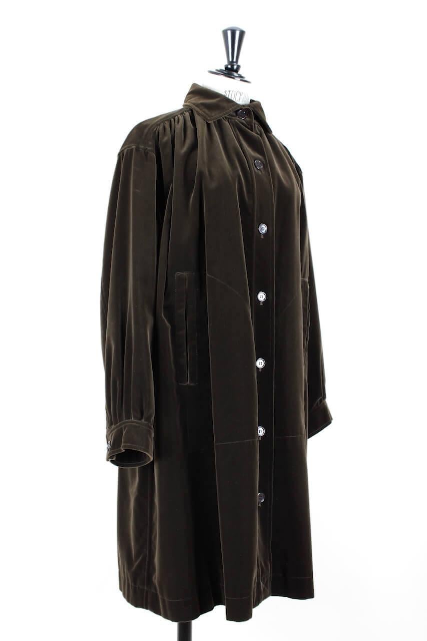 This easy to wear Yves Saint Laurent coat from the early 1980s is made from plush chocolate brown velvet. The design is meant to be worn loose and has a bit of an artist's smock. It features the characteristic smock style yoke front and back with