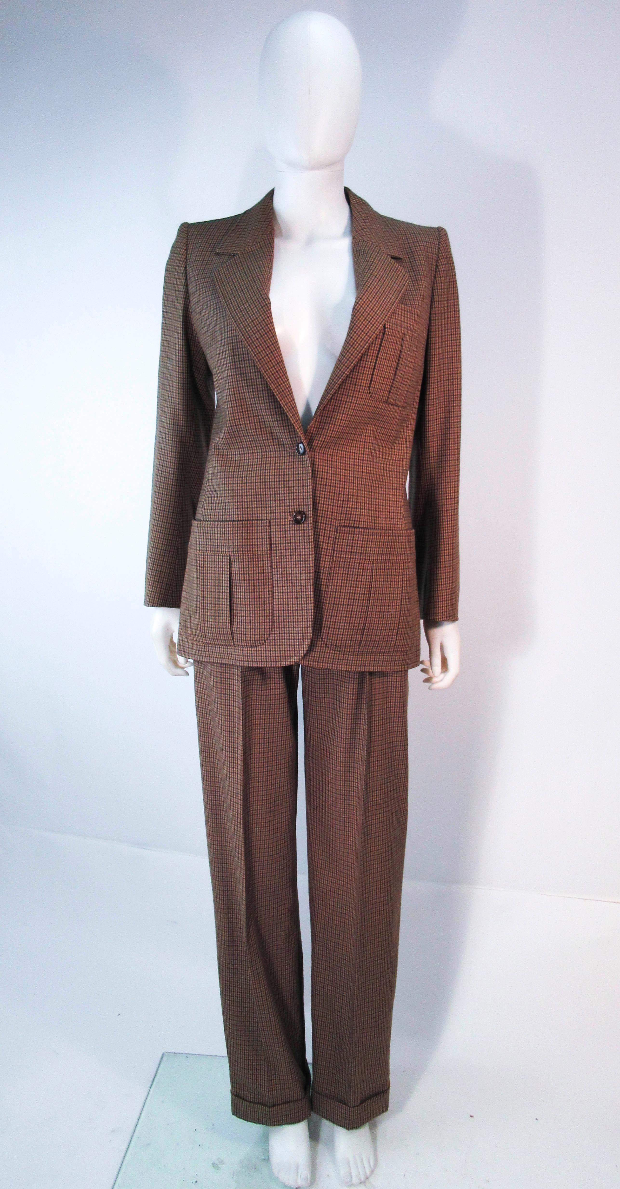 This Yves Saint Laurent suit is composed of a brown grey plaid wool. Features a beautiful classic blazer with pockets and a wonderful pleated trouser with belt. In excellent vintage condition (some signs of wear due to age). Made in