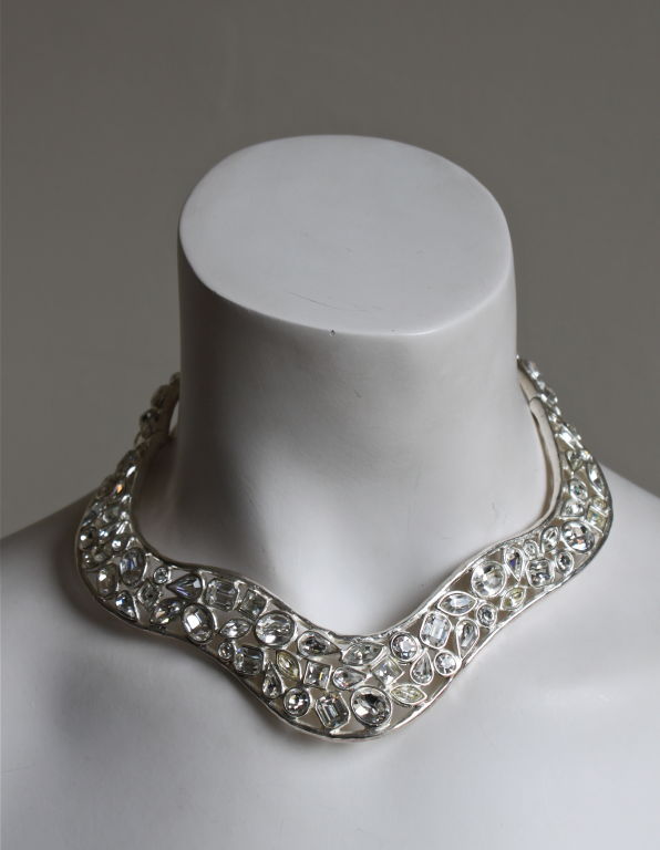 Detailed silver-toned collar with dozens and dozens of clear faceted glass crystal stones designed by Yves Saint Laurent dating to the late 20th century. Hinged on each side at back for easy entry. Measures approximately 13.5