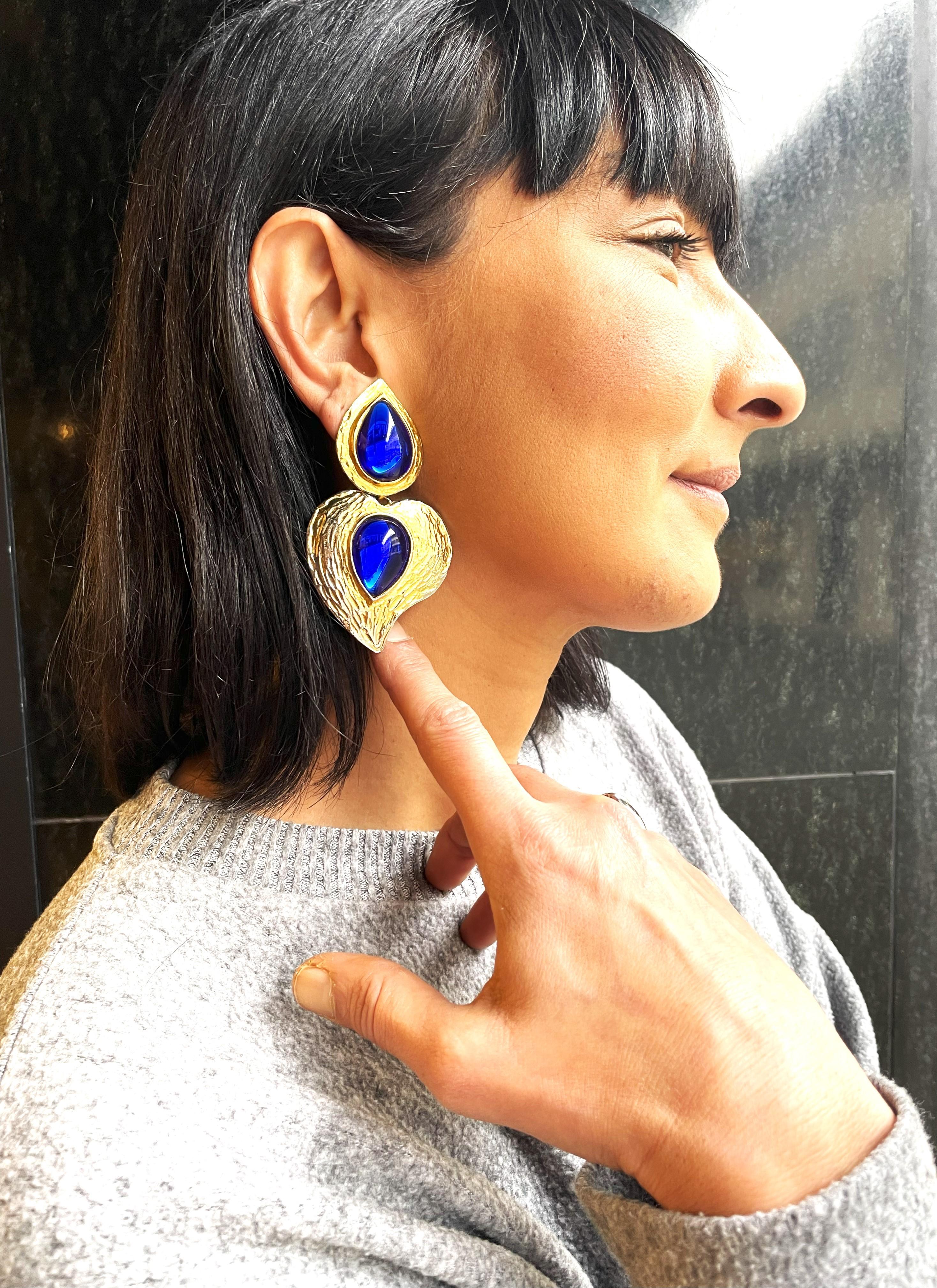 1 paio di fermagli decorativi per orecchie di Yves Sant Laurent Paris della fine degli anni '80. Si compone di 2 parti, con 2 grandi pietre di vetro a forma di goccia.

Dimensioni:
Lunghezza totale 8 cm 
Gocce superiori altezza 3,5 cm x larghezza