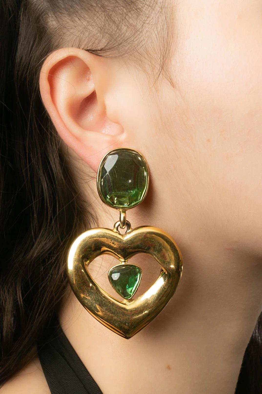 Yves Saint Laurent (Made in France) Clip-on gilded metal earrings holding a heart and decorated with green resin cabochons.

Additional information:
Dimensions: 5 W x 7.7 H cm (1.96