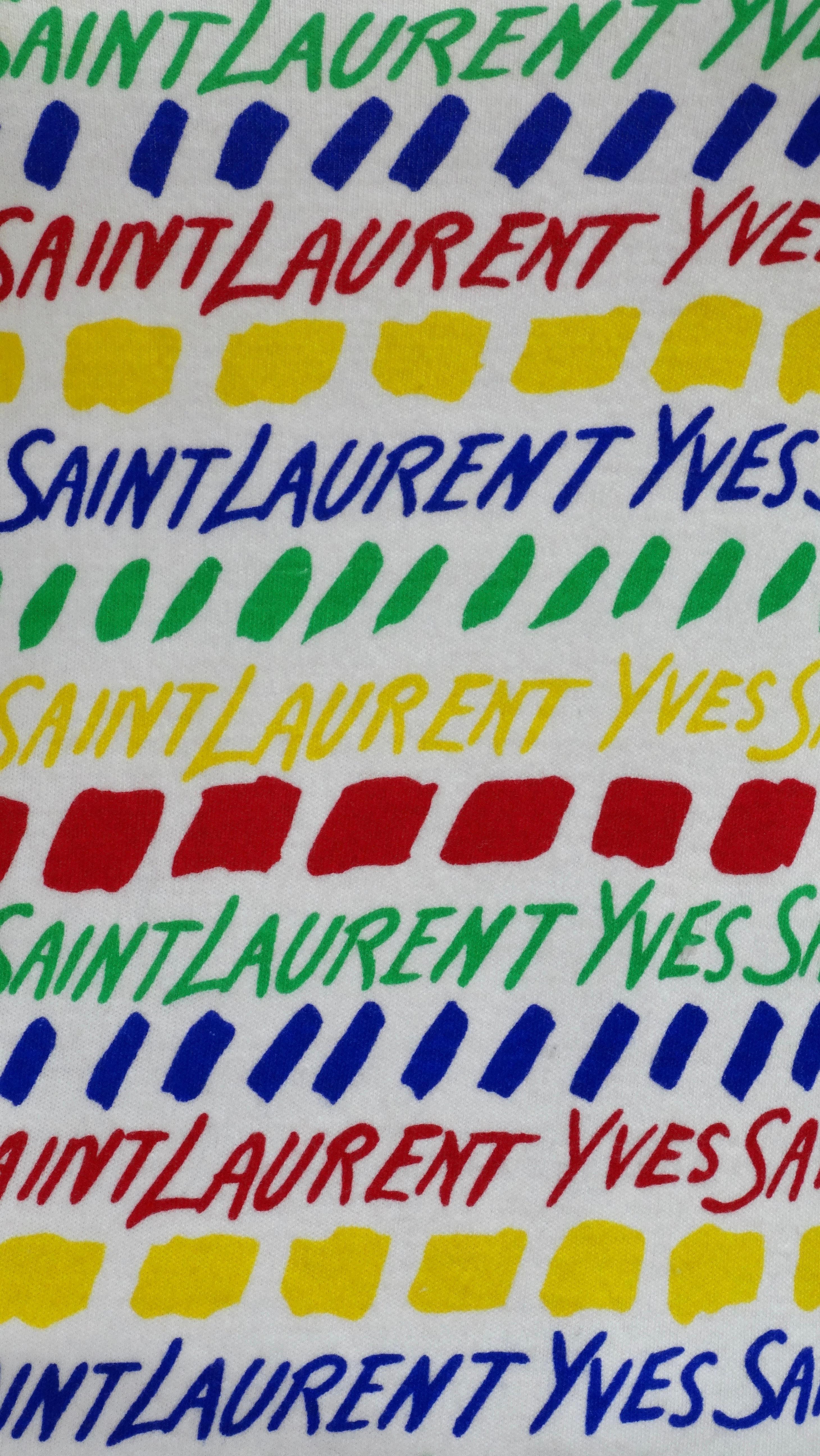 Une pièce funky et fraîche à ajouter à votre collection. De Saint Laurent lui-même, dans les années 1970, c'est une pièce tout droit sortie de l'histoire quand ils ont commencé à faire des monogrammes. Il s'agit d'un haut en coton avec une coupe