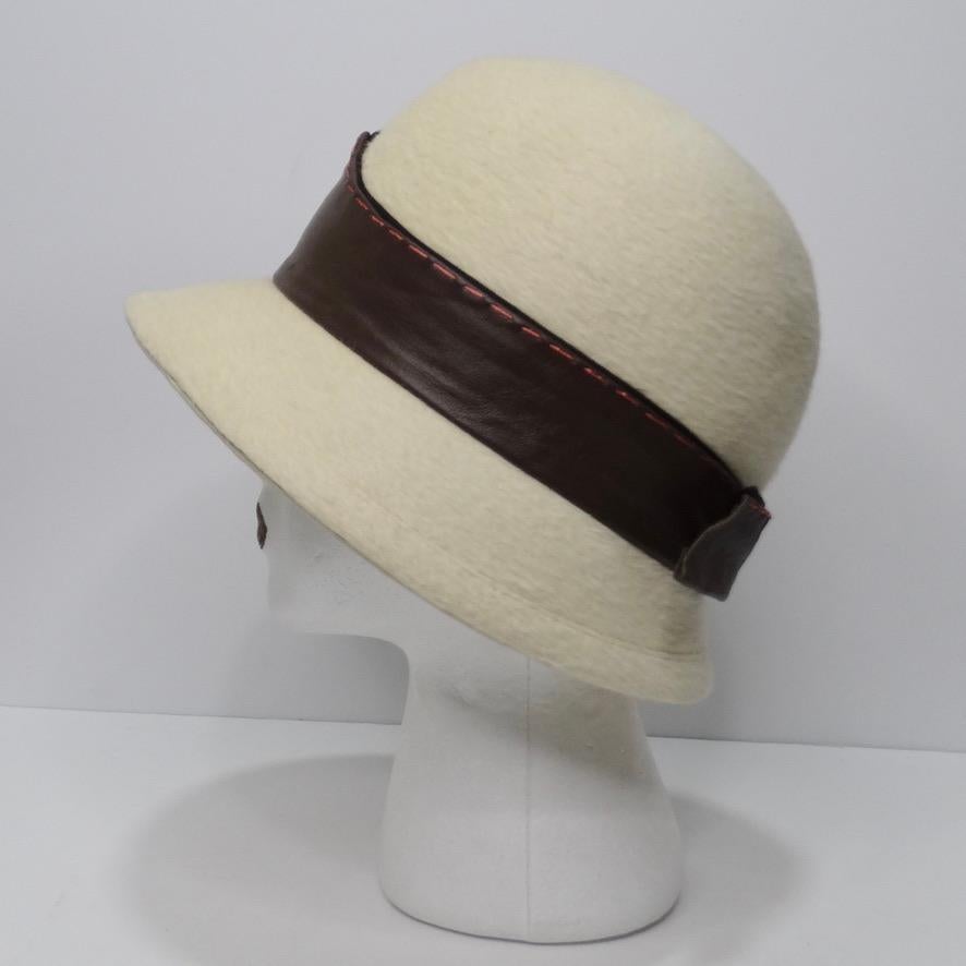 This classic Pharrell style,  vintage Yves Saint Laurent Hat is so versatile and a staple for any hat collector. In a gorgeous off-white wool fabric, brown leather wraps around the center of the hat and ties in the back. The style of this hat is