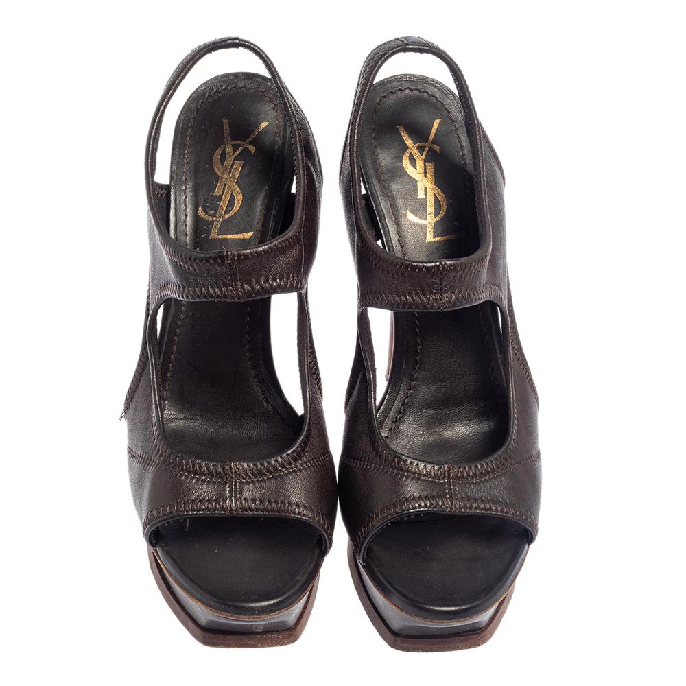 The house of Yves Saint Laurent brings you these impressive sandals that will complement any outfit. They have been crafted from dark brown soft leather and are styled with open toes. They are equipped with platforms, 13.5 cm heels and leather