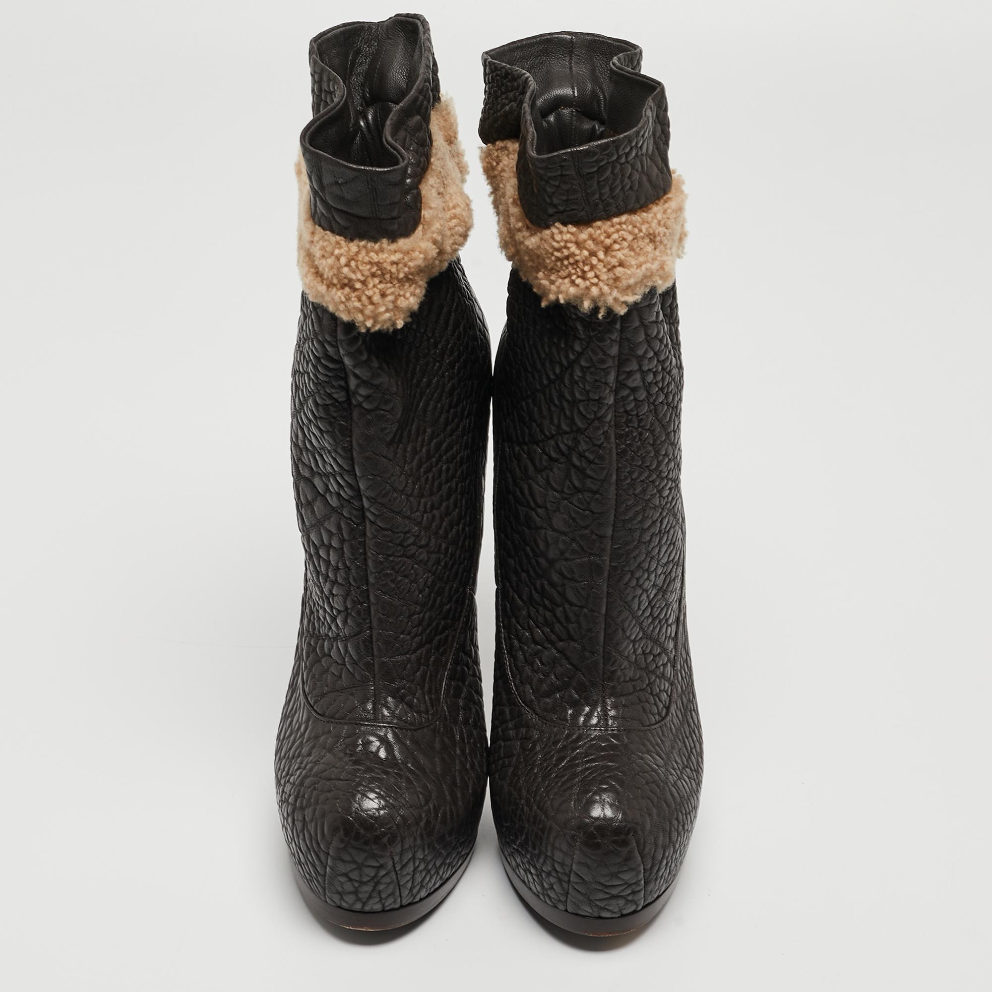 Nail a confident look with these designer ankle boots from Yves Saint Laurent! They're made of textured leather and added with contrasting fur-like trims, platforms, and 14 cm heels.

Includes
Original Dustbag