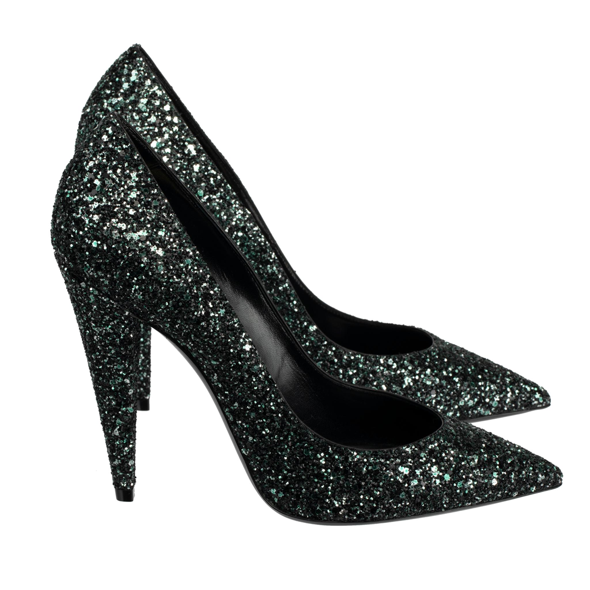 The Yves Saint Laurent Decollete Era Pumps offer a luxurious take on the classic heel. Crafted from black and emerald green glitter, this chic design is perfect for elevating any evening look. With a sleek, sophisticated silhouette, these sparkling