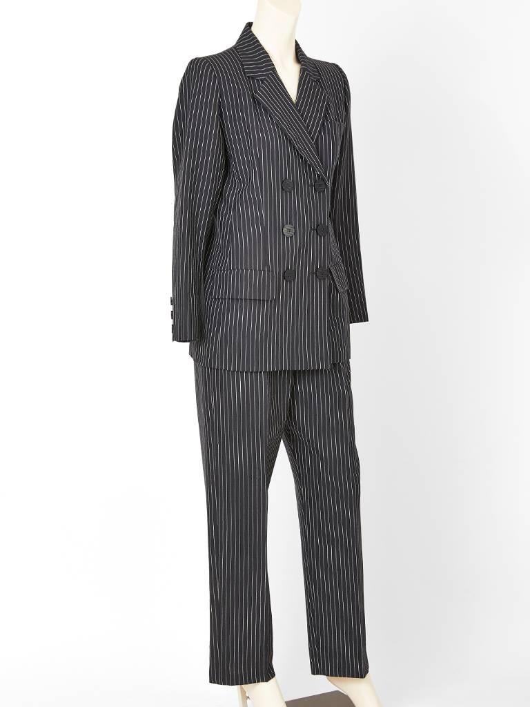 Yves Saint Laurent, Rive Gauche, light weight wool, double breasted pant suit, having a black ground with white pinstripes. Men's style trousers have a fly front, and a straight leg. 