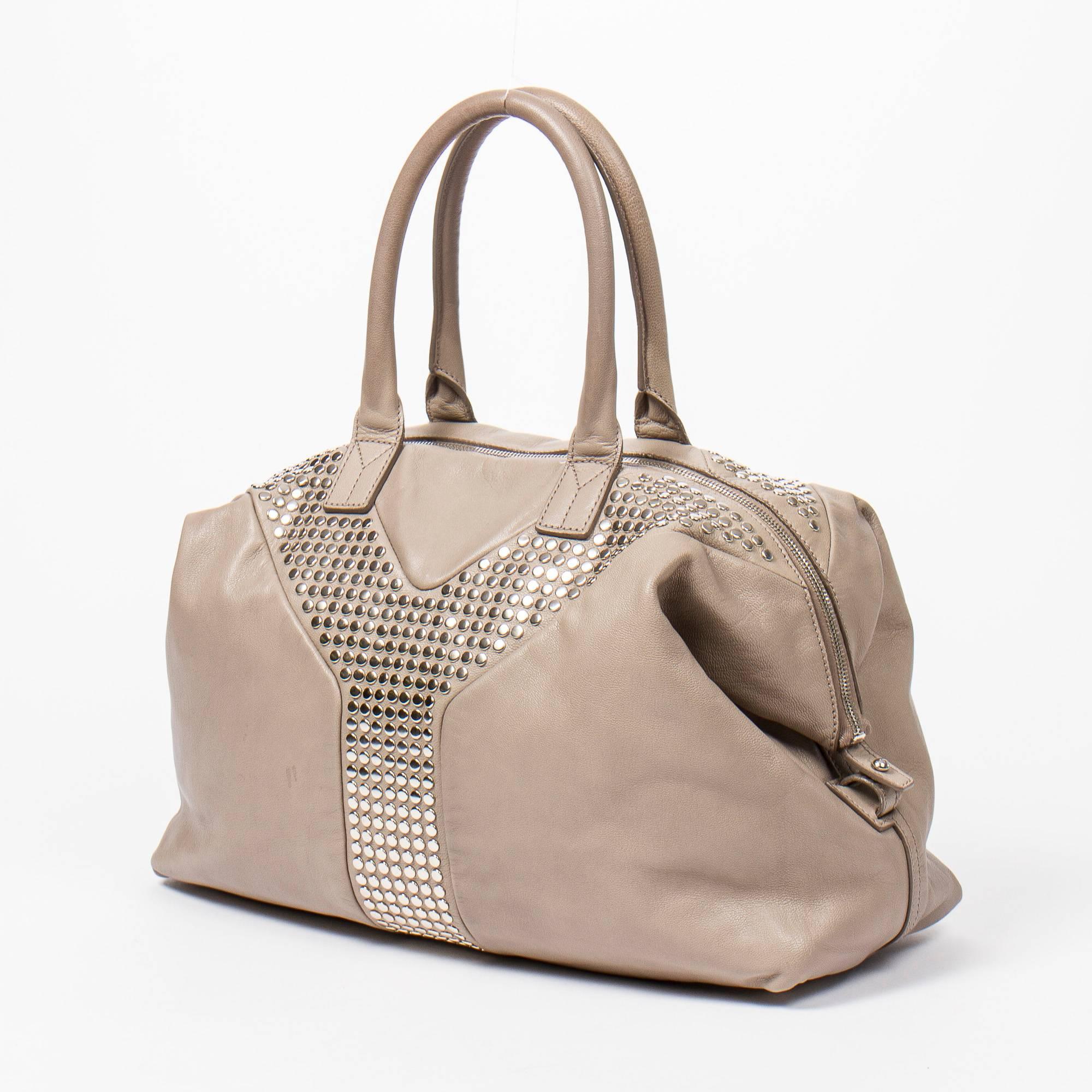 Yves Saint-Laurent Easy Studded MM in light grey small grained leather and silver hardware. Canvas lined wide inside pocket with a zip closure. Very good condition overall.