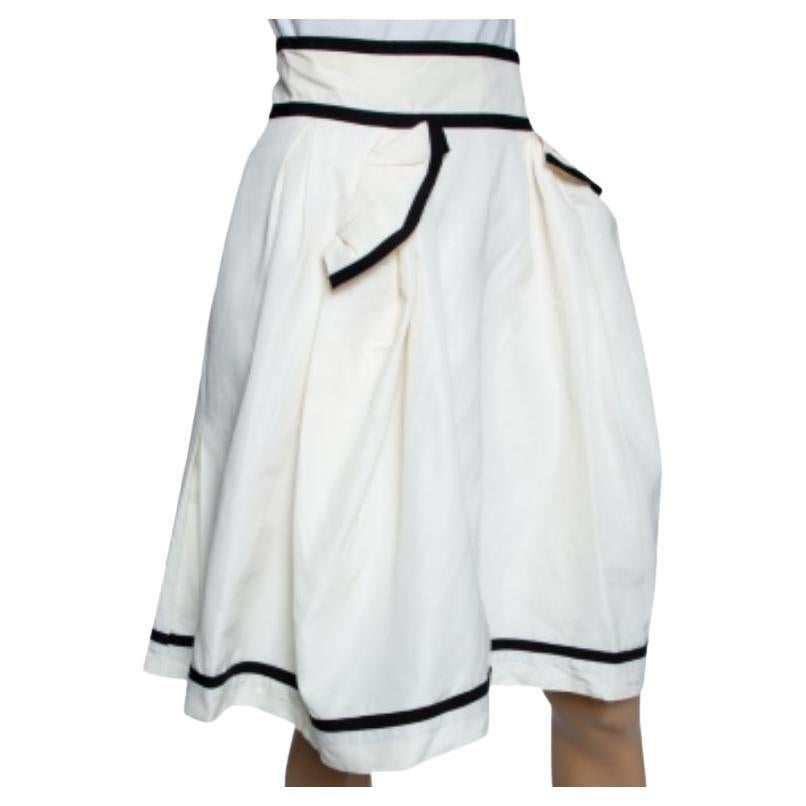 El talento de Yves Saint Laurent para confeccionar siluetas femeninas con elementos elegantes hace que sus creaciones sean aún más atractivas y chic. Esta preciosa falda se ha confeccionado en tejido de algodón blanco crudo, adornado con detalles de