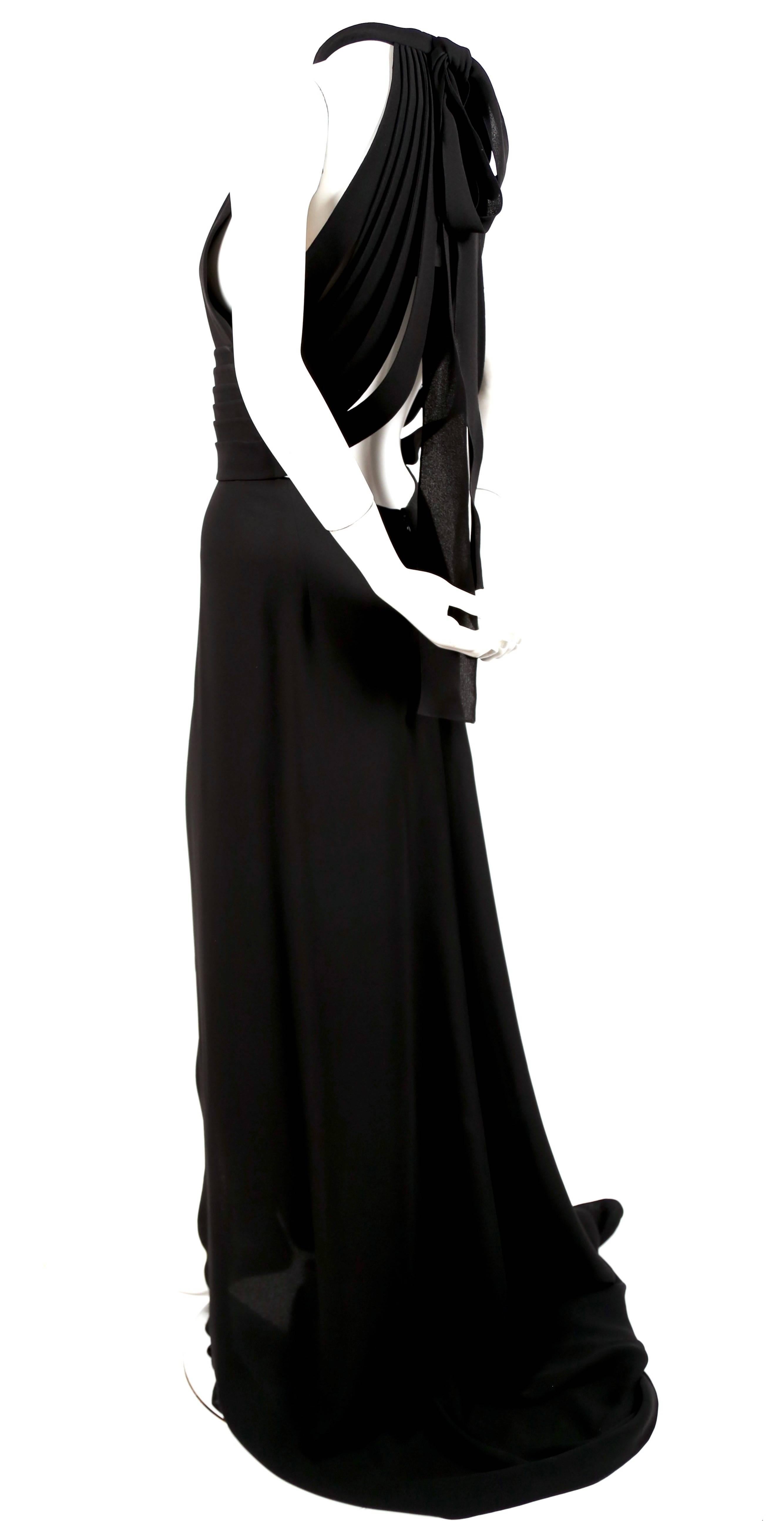 Dramatic jet black silk evening gown with elaborate straps at back from Yves Saint Laurent 'edition soir'. Labeled a French size 42 although this dress runs small and would better fit a French 40. Dress measures approximately 34-36