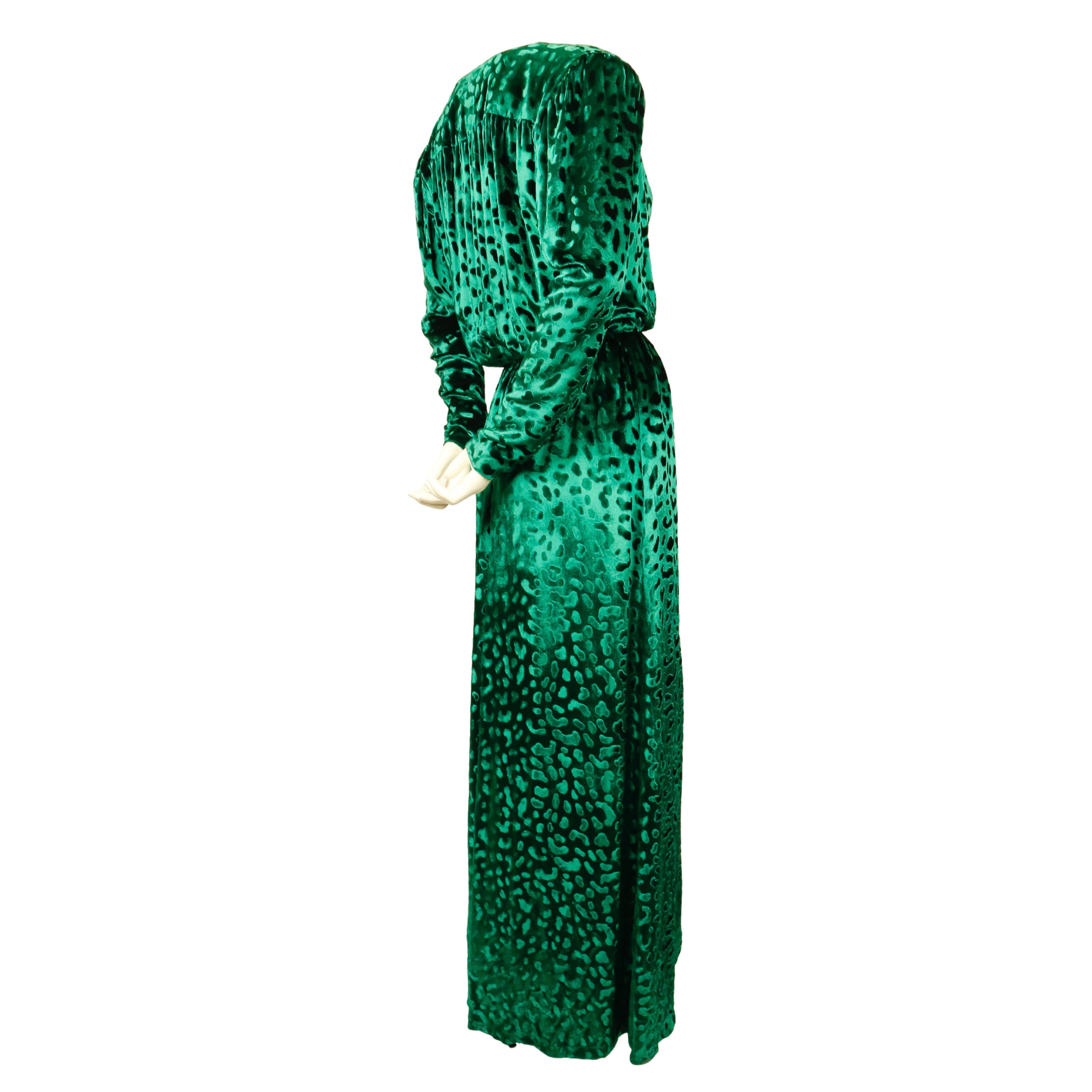 Vivid, emerald-green 'leopard' velvet evening gown with low cut neckline and long sleeves and zip cuffs designed by Saint Laurent dating to 1986. Variations of this gown were shown on Saint Laurent's runways through the mid 1980's. French size 38.