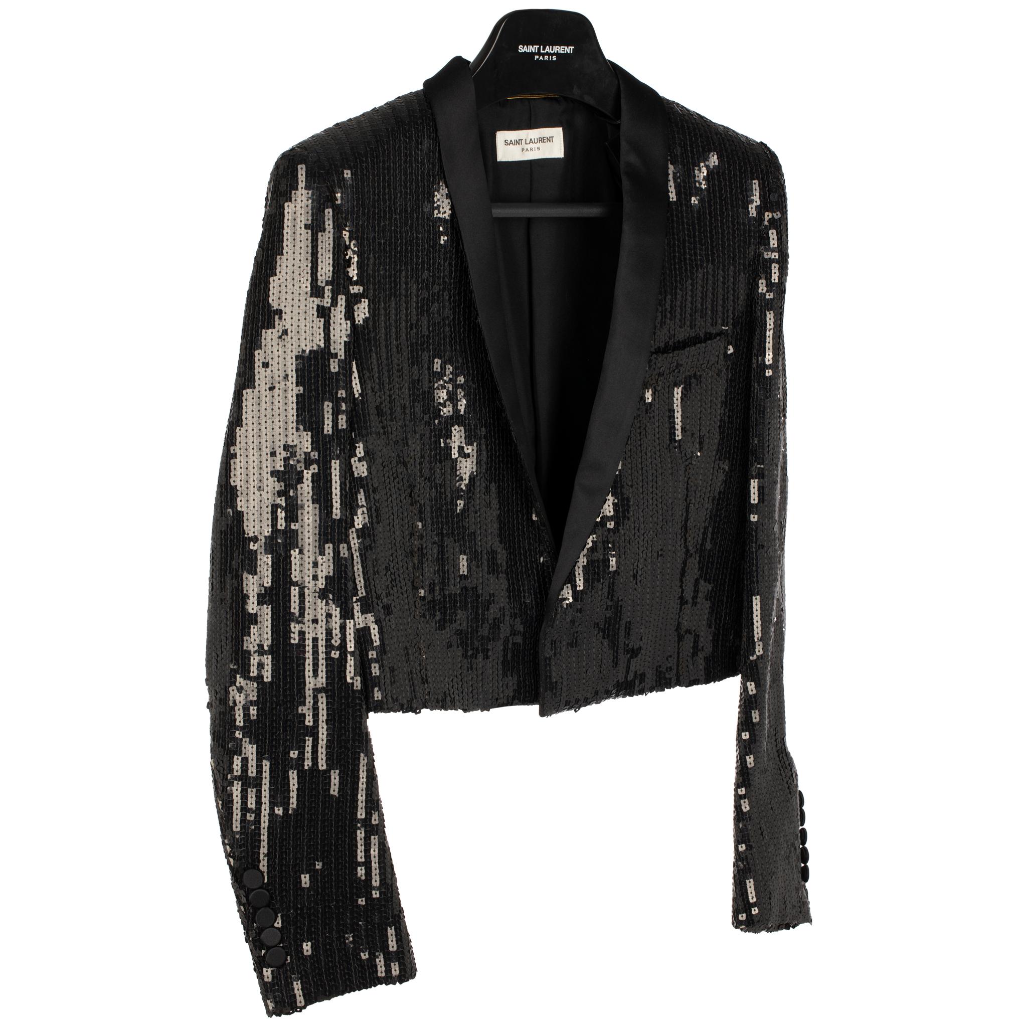 Setzen Sie mit dieser Yves Saint Laurent Crop-Jacke für den Abend ein mutiges Statement. Das Modell aus schwarzem Paillettenstoff verleiht Ihrem Abend in der Stadt einen Hauch von Stil. Dieser vollständig gefütterte Blazer ist Ihr Lieblingsstück für