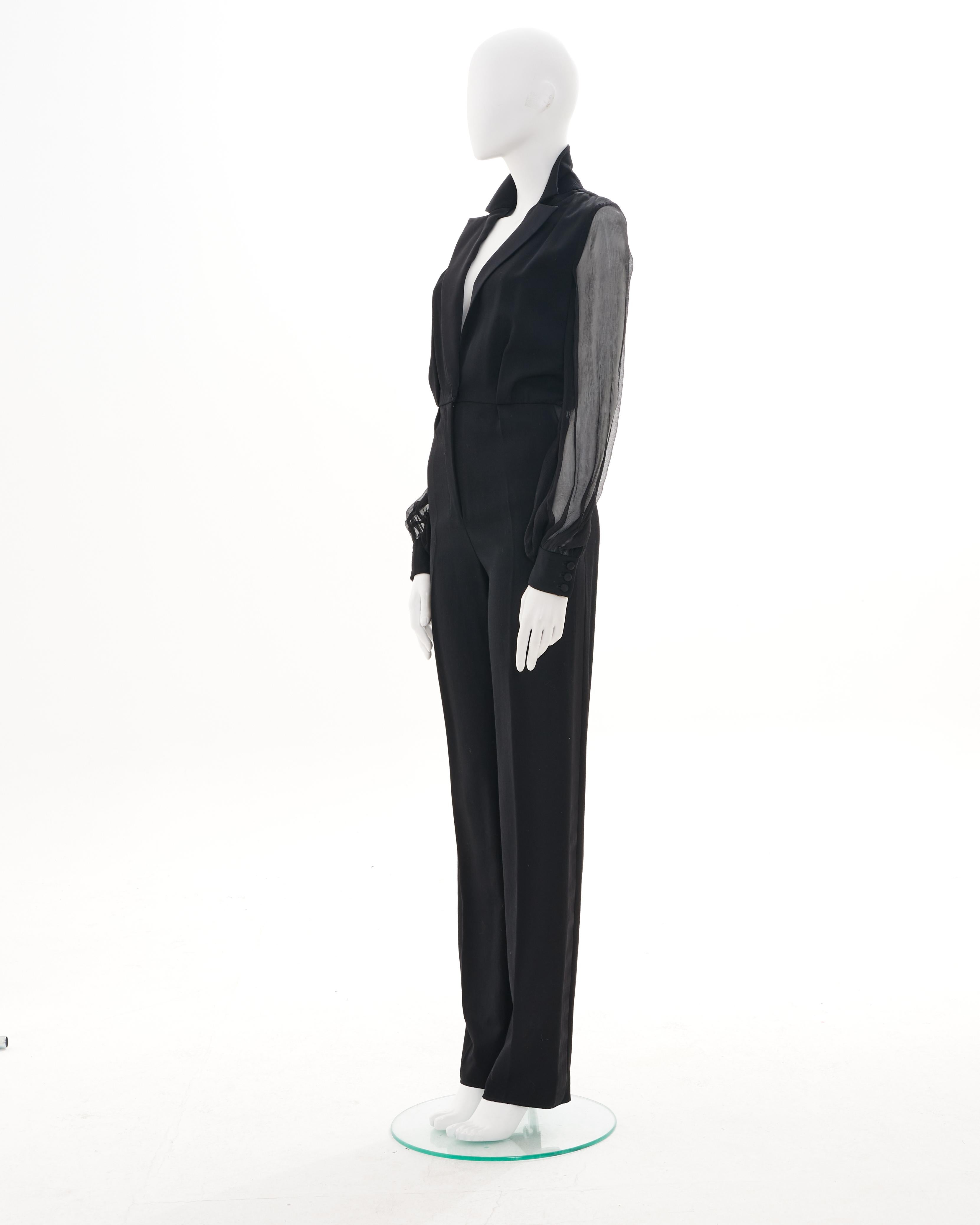 - Conçu par Tom Ford
- Vendu par Skof.Archive
- Collection automne-hiver 2001
- Costume de smoking noir
- Manches longues structurées et transparentes
- Fermeture à bouton unique
- Pantalon droit à taille haute
- Fabriqué en Italie
- Excellent